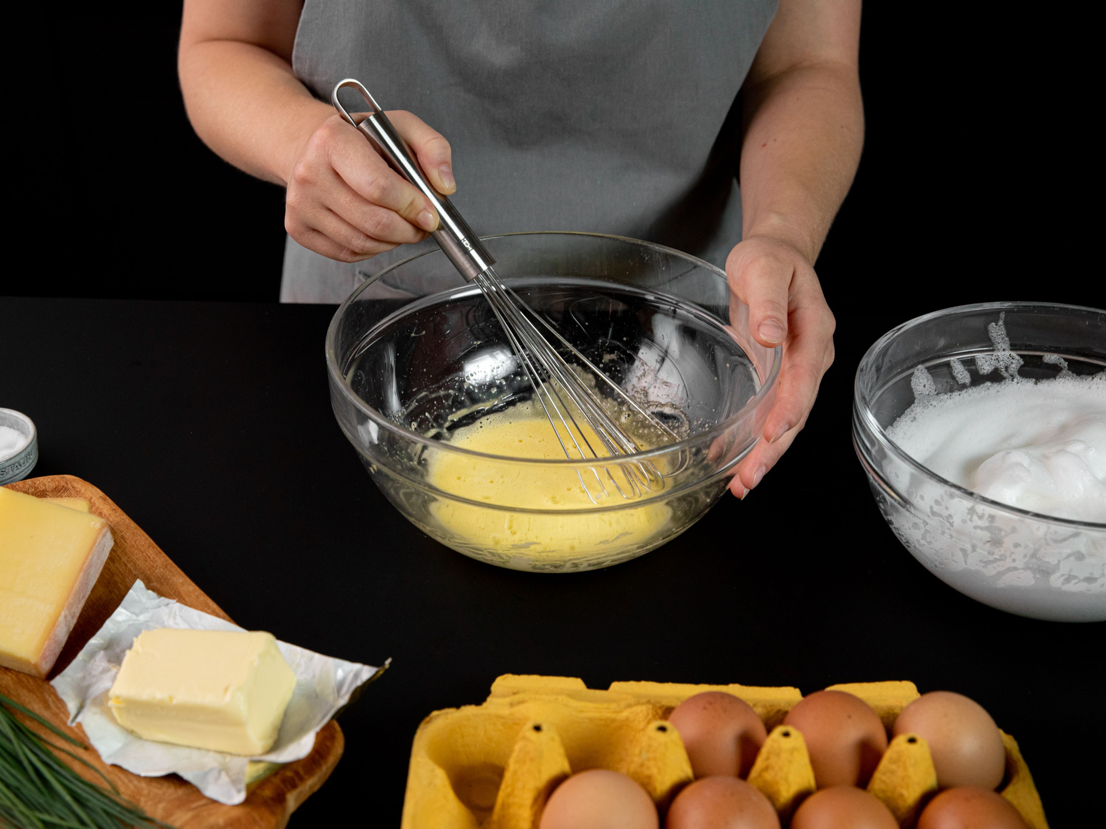 Eier trennen und Eiweiß und Eigelb in getrennte Schüssel geben. Eiweiß salzen und aufschlagen, bis sich feste Spitzen bilden. Eigelb aufschlagen.