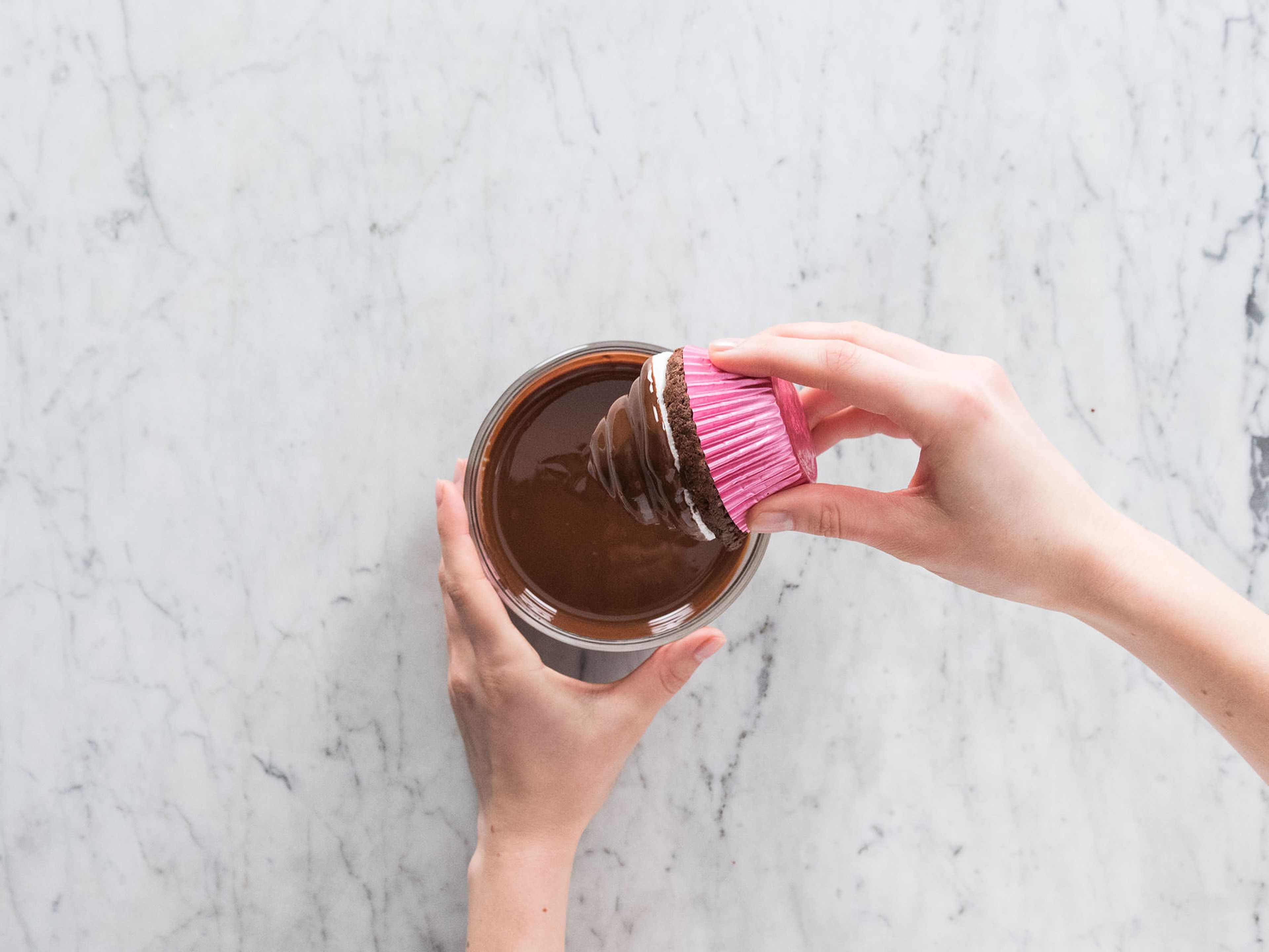 In einer kleinen Schüssel die restliche geschmolzene Schokolade mit Öl glattrühren und ca. 5 Min. abkühlen lassen. Sobald die Glasur lauwarm ist, die Cupcakes darin eintauchen. Danach antrocknen lassen und genießen! Guten Appetit!