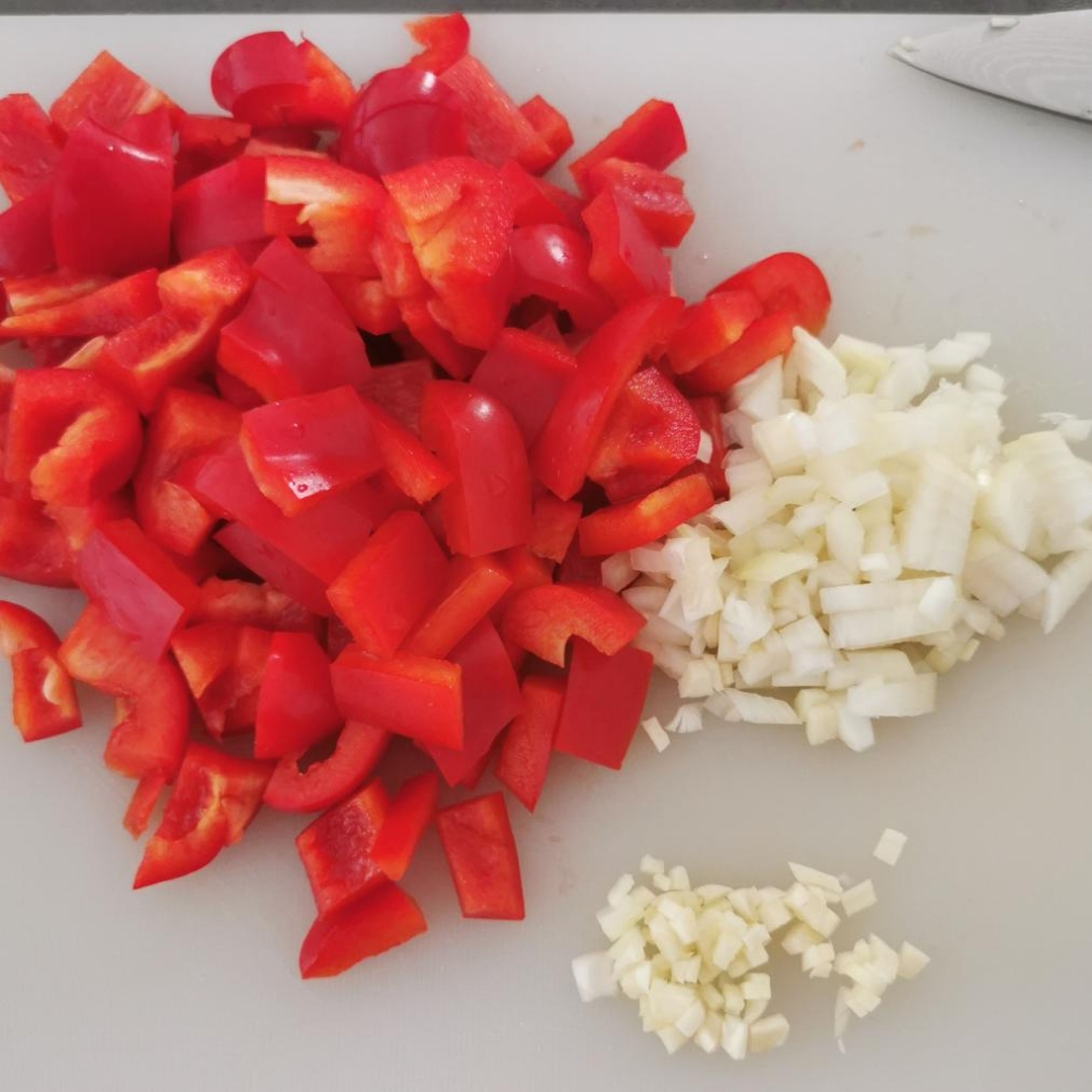 Zwiebel, Knoblauch und restliche Paprika klein schneiden.
