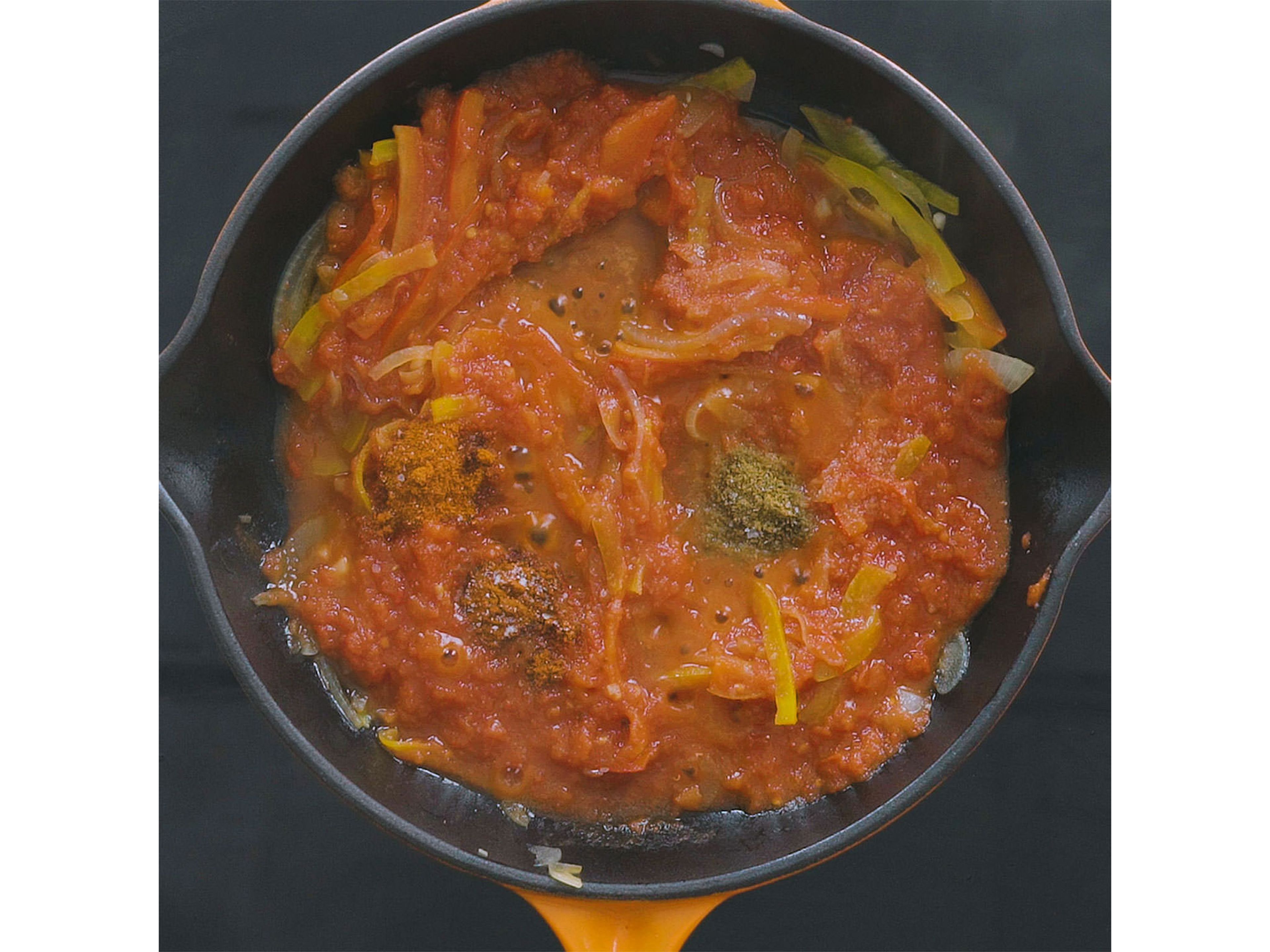 Gehackte Tomaten, Paprikapulver, Kreuzkümmel und Cayennepfeffer hinzufügen und für weitere ca. 5 Min. köcheln lassen. Mit Salz und Pfeffer abschmecken.