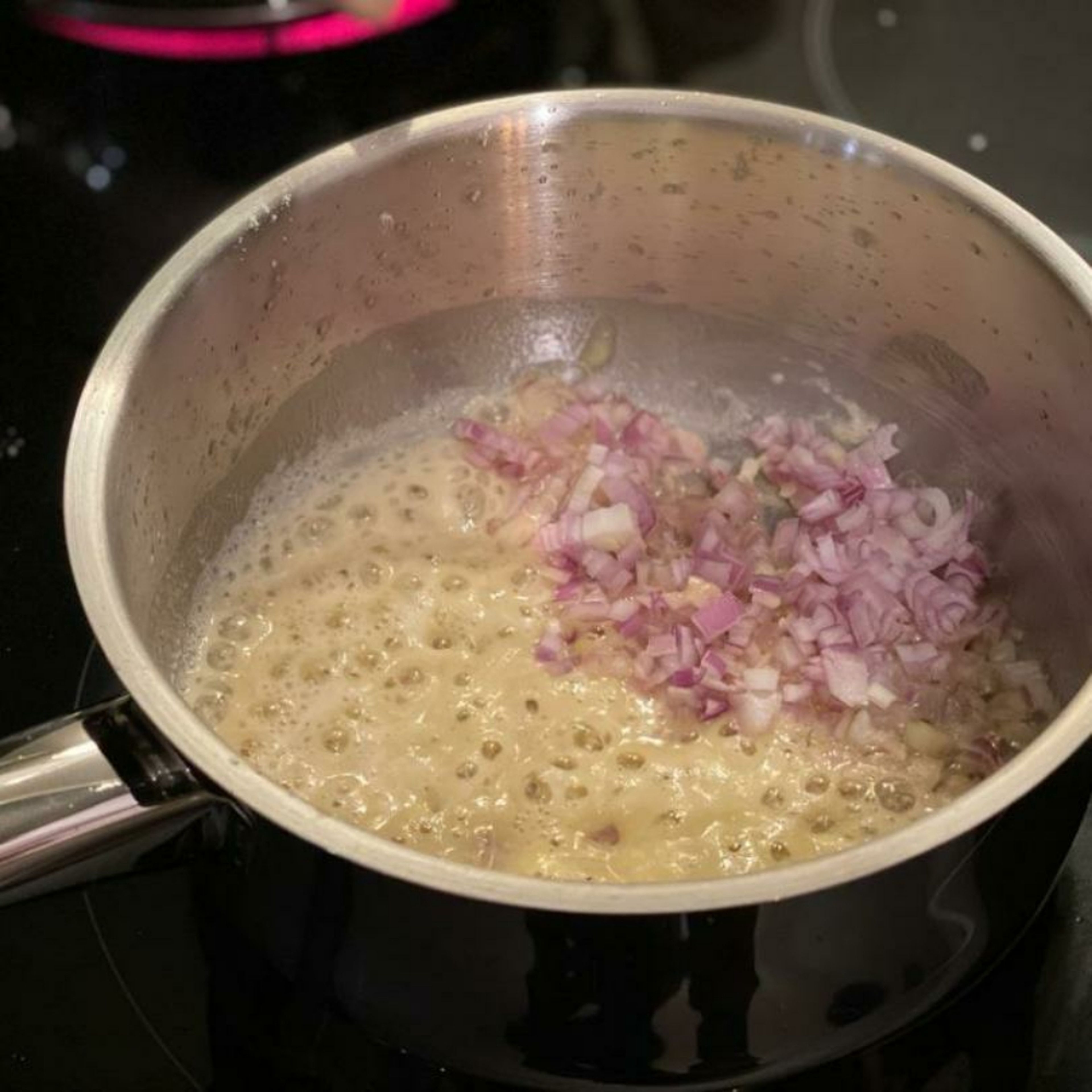 Die Butter in einem Topf schmelzen. Mehl dazugeben und kräftig rühren damit es eine gleichmäßige Mehlschwitze ergibt. Die Zwiebeln und den Knoblauch dazugeben und ca. 3 Min. darin glasig schwitzen.