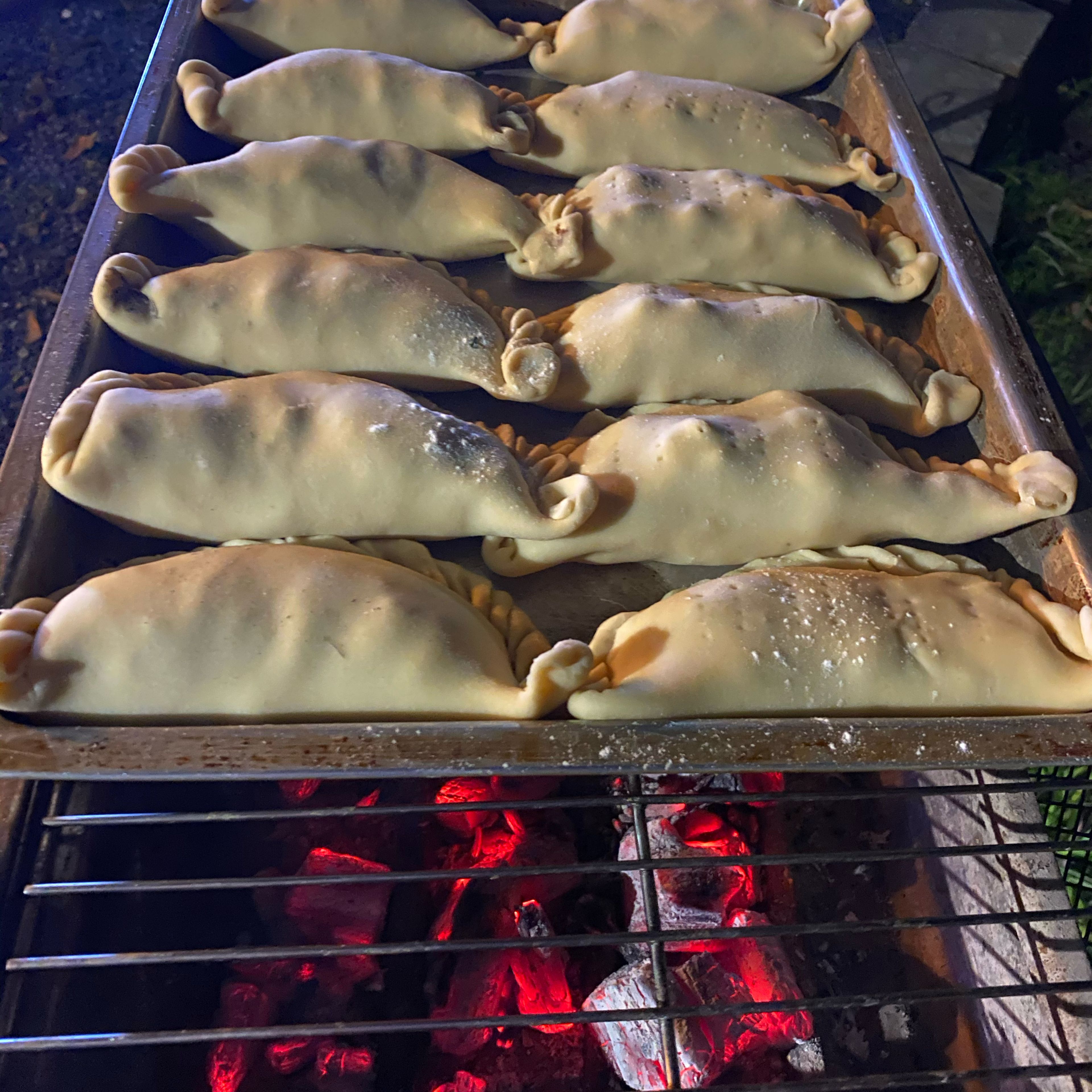 Grilled Empanadas:

put them directly on the grill of your campfire for 3-5 minutes depending on its temperature.Remove, let cool down and enjoy!