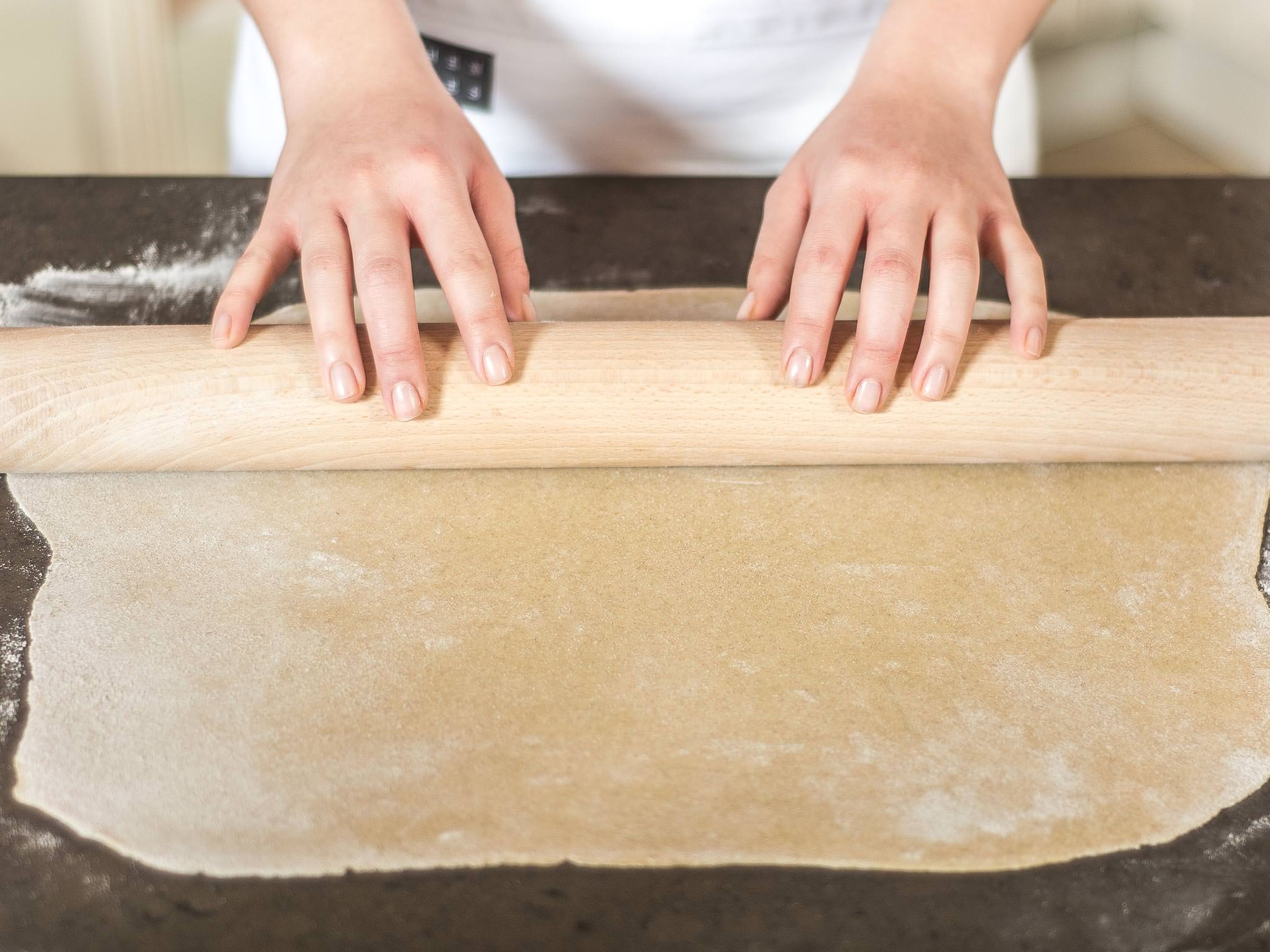 Divide the dough into two equal pieces and roll out each until flat on a work surface sprinkled with flour. Transfer to a lined baking tray.