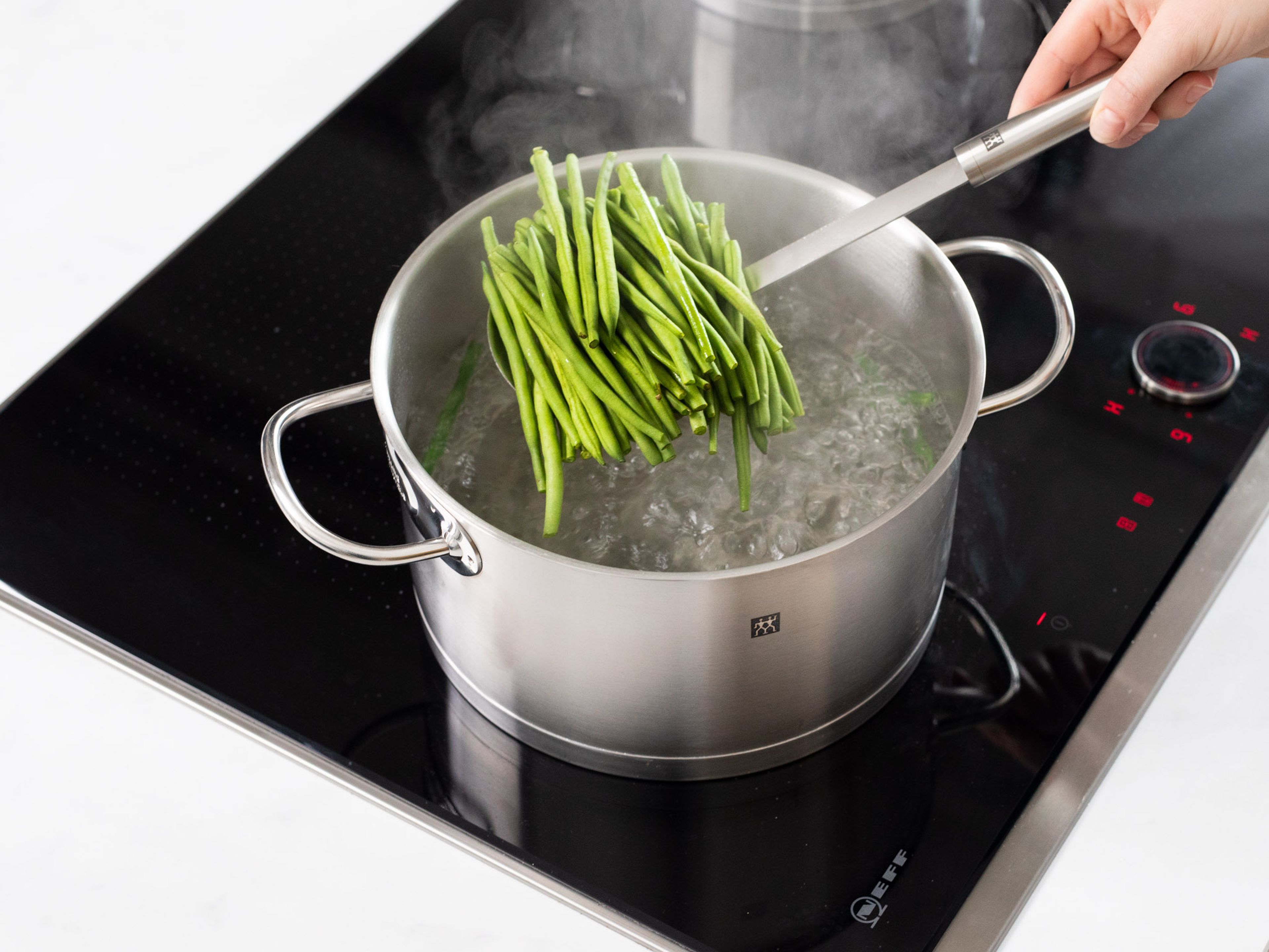 Boil potatoes in salted water until tender. Blanch the green beans for approx. 2 min. and transfer immediately to a large bowl of ice water.