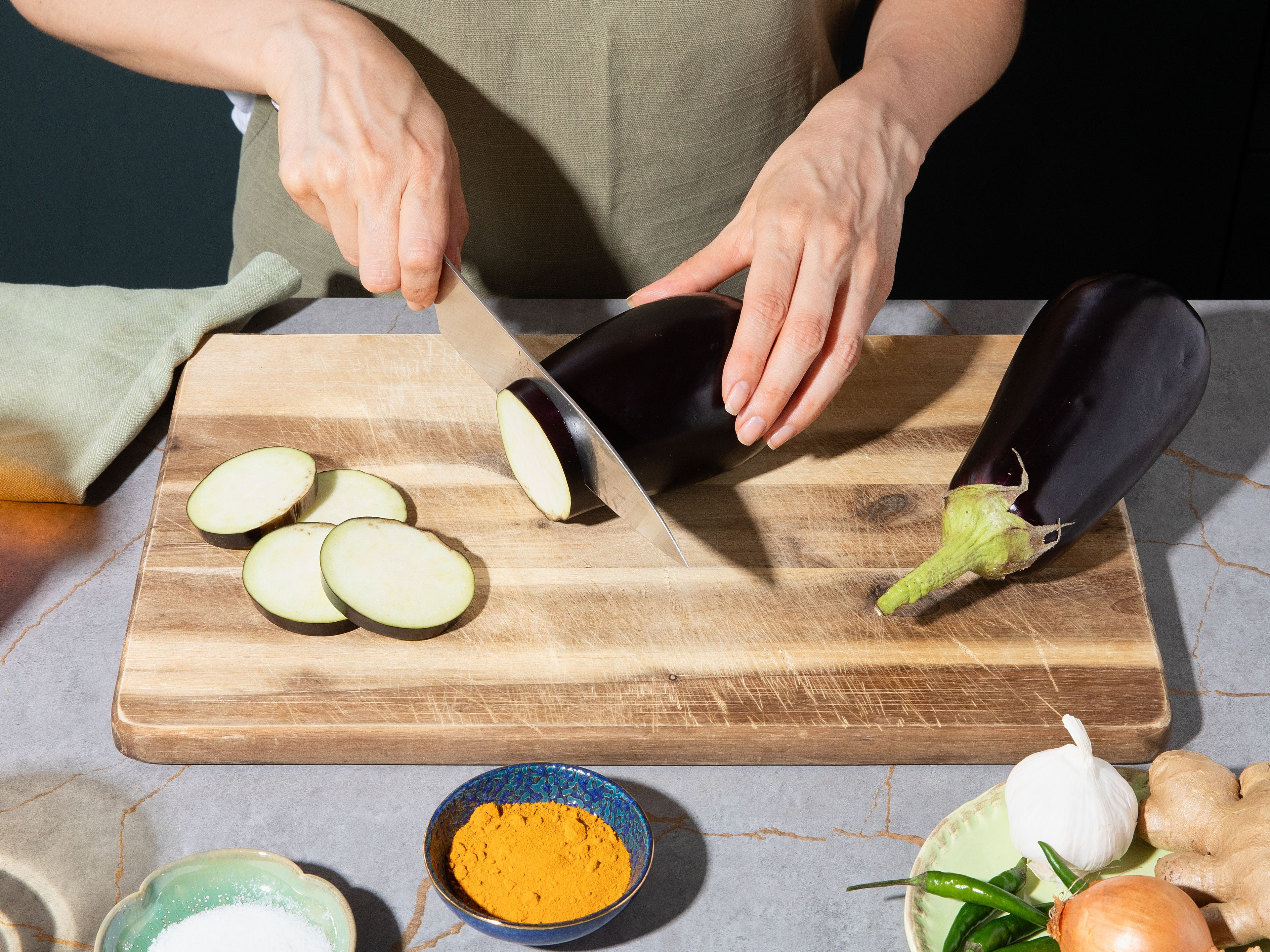 Preheat oven to 220°C/425°F (upper/lower heat). Slice eggplants into approx. 0.7 cm/0.3 in. thick rounds, season lightly with salt, and let sit for approx. 5–10 min. Pat dry afterwards. Toss with turmeric and part of the oil, then spread on baking sheet lined with parchment paper. Add to the preheated oven and roast for approx. 25 min. until golden brown and soft.