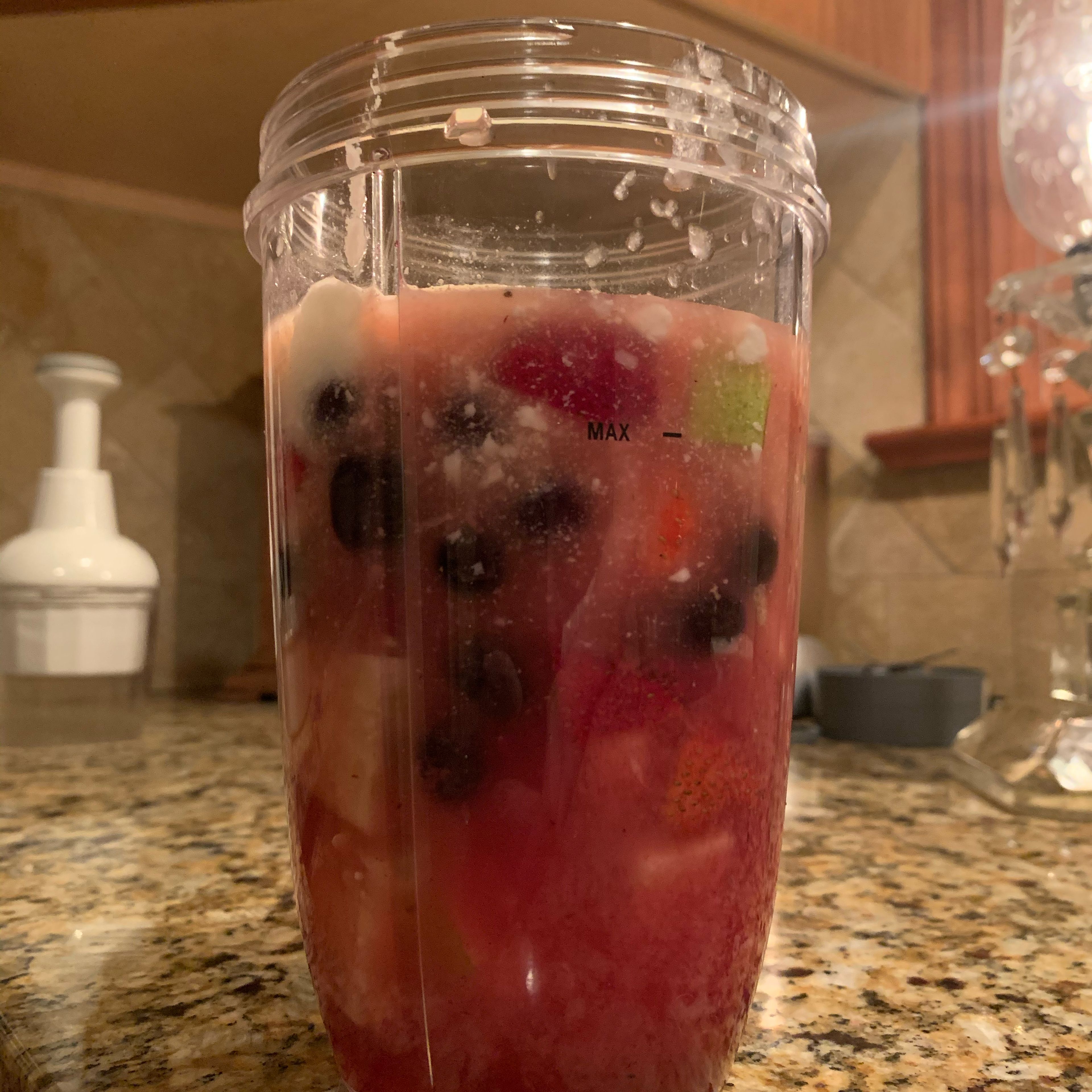 Add all ingredients to a blender or Nutribullet cup, including the fruit bowl. Add vodka in varying amount based on strength preference. 4 or 5 tablespoons typically makes for a medium to strong drink. Blend mixture.