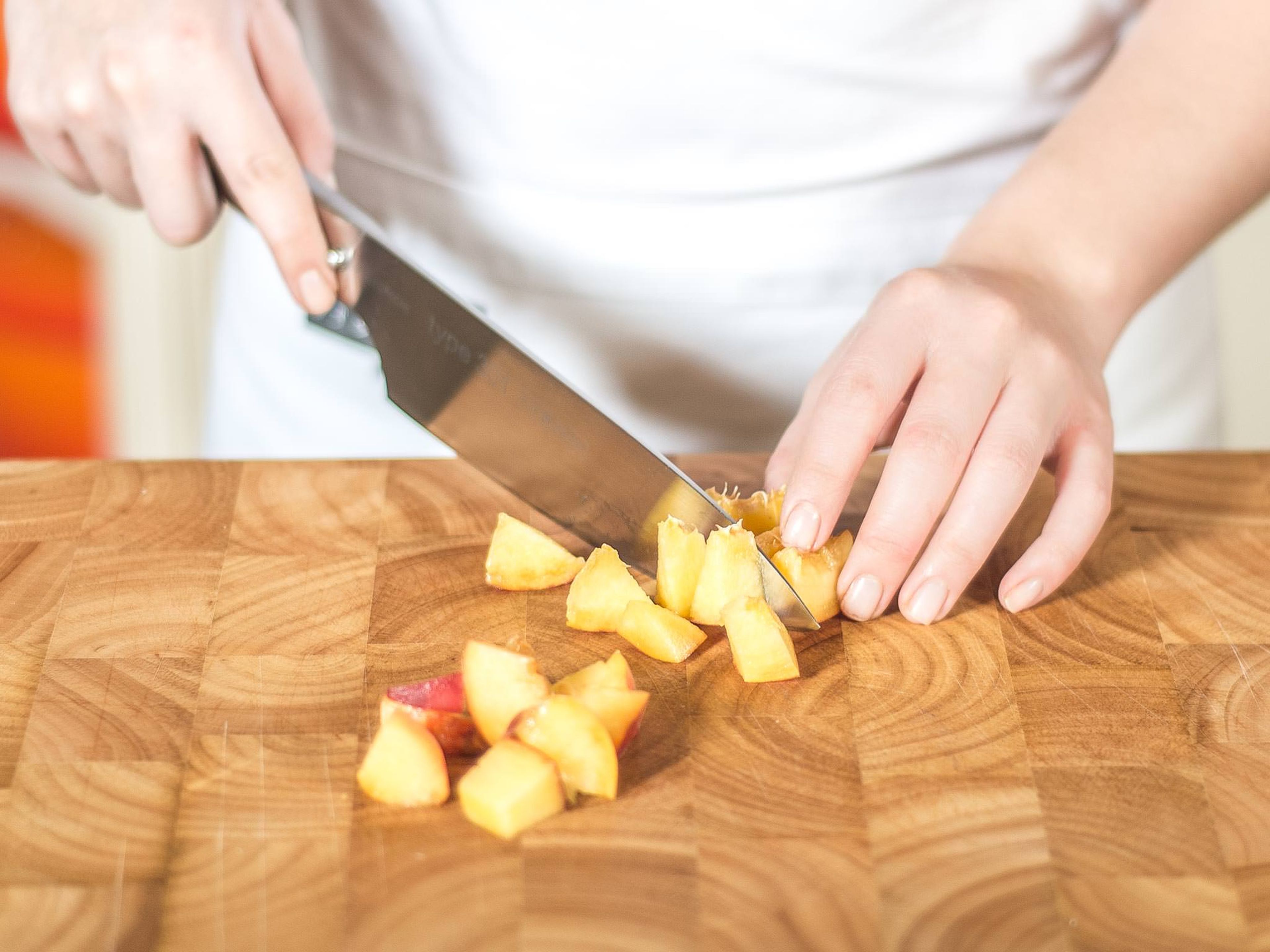 Für das Pfirsichkompott die Pfirsiche entsteinen und in mundgerechte Würfel (ca. 1 cm x 1 cm) schneiden.
