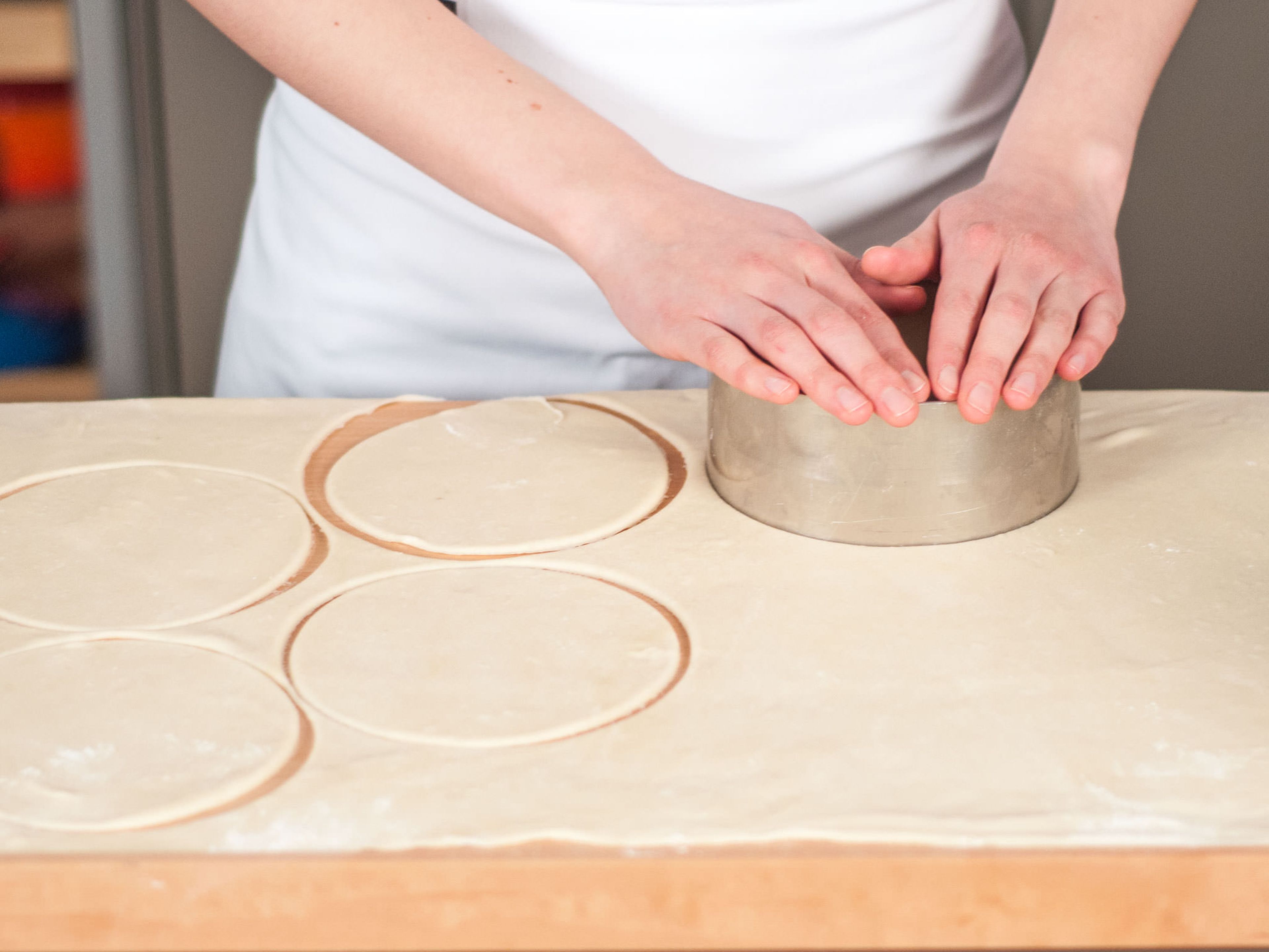 Backofen auf 180°C vorheizen. Arbeitsfläche leicht bemehlen. Teig mit dem Nudelholz dünn ausrollen. Mit einem Ausstecher Kreise ausstechen.
