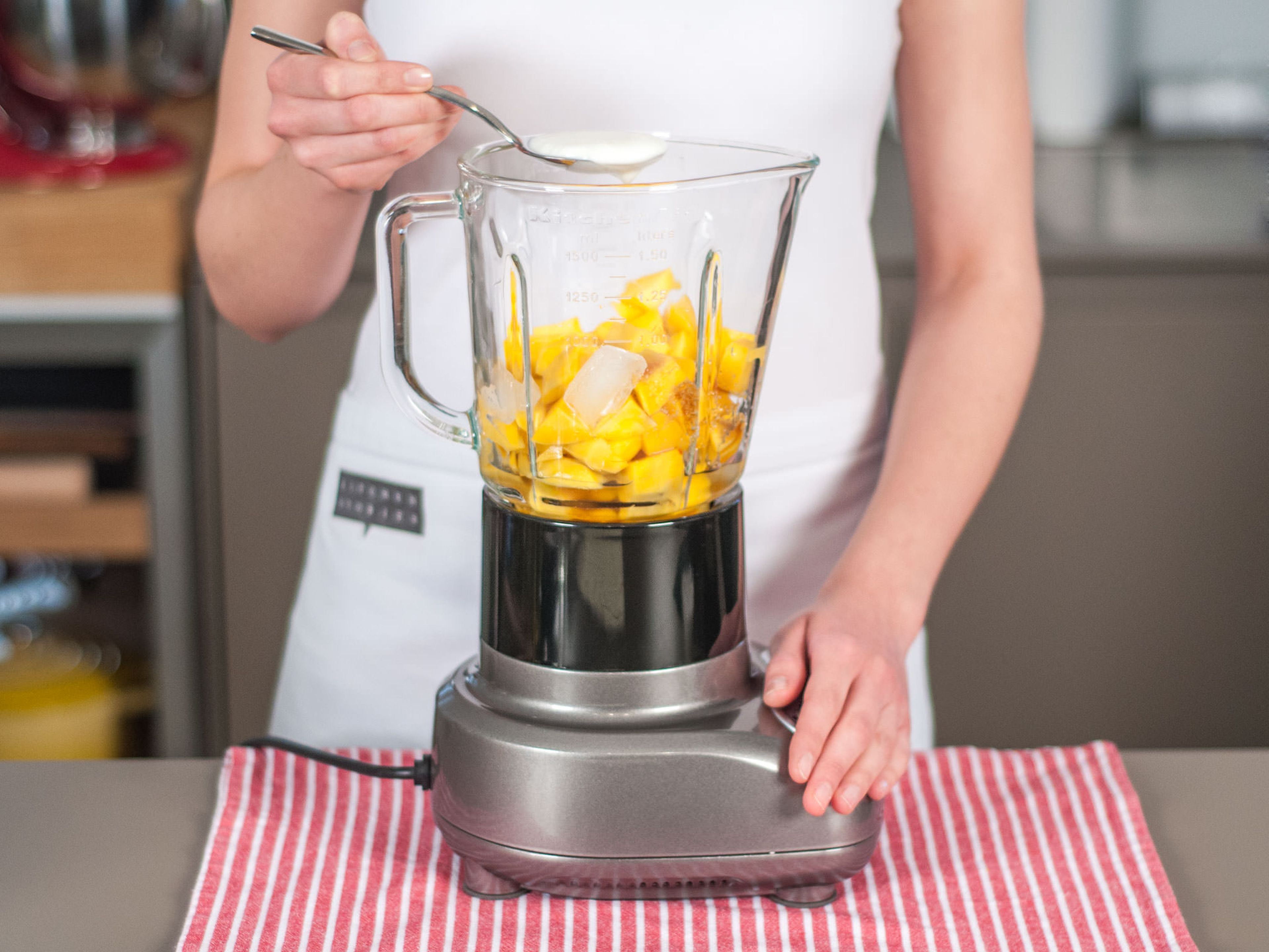 Add mangoes, ice cubes, cold water, honey, and yogurt to blender.