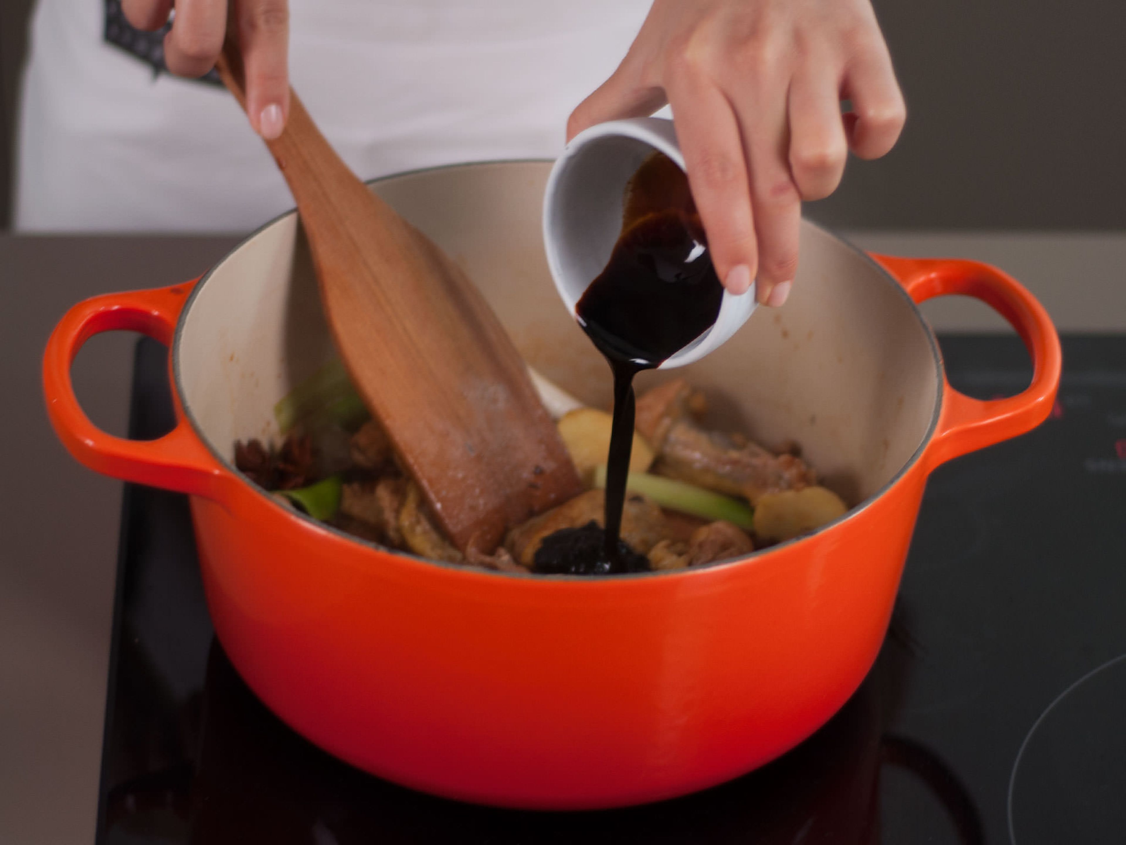 Add white wine as well as light and dark soy sauces to saucepan. Stir to coat chicken and vegetables, cover with a lid, and let cook for approx. 1 – 2 min.
