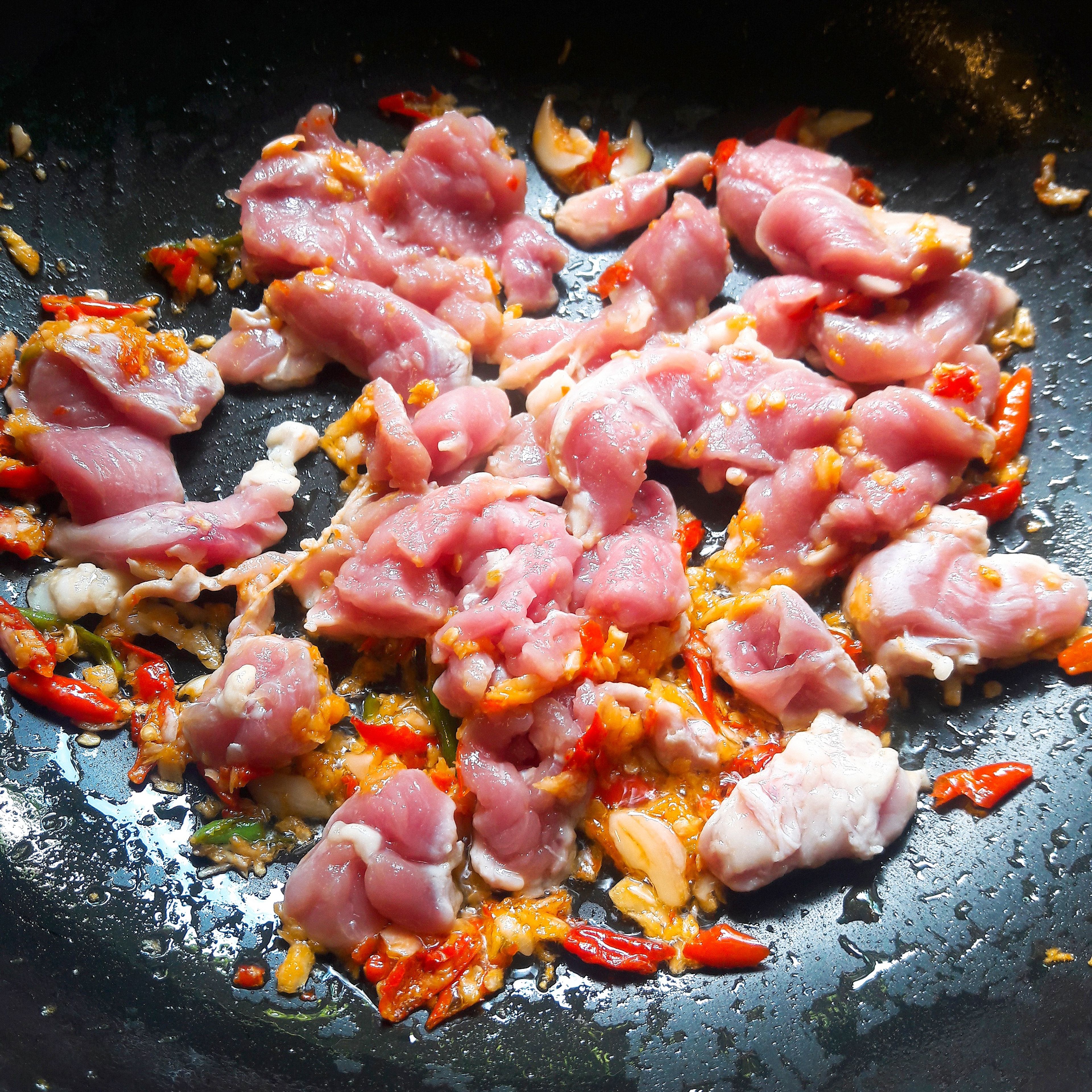 Heat the vegetable oil in a frying pan or a wok over high heat. Add the garlic and chili paste and cook for another 30 seconds. Then add the sliced pork and stir-fry 3-4minutes or until the pork is cooked. Add oyster sauce, fish sauce and sugar and stir-fry until well combined.