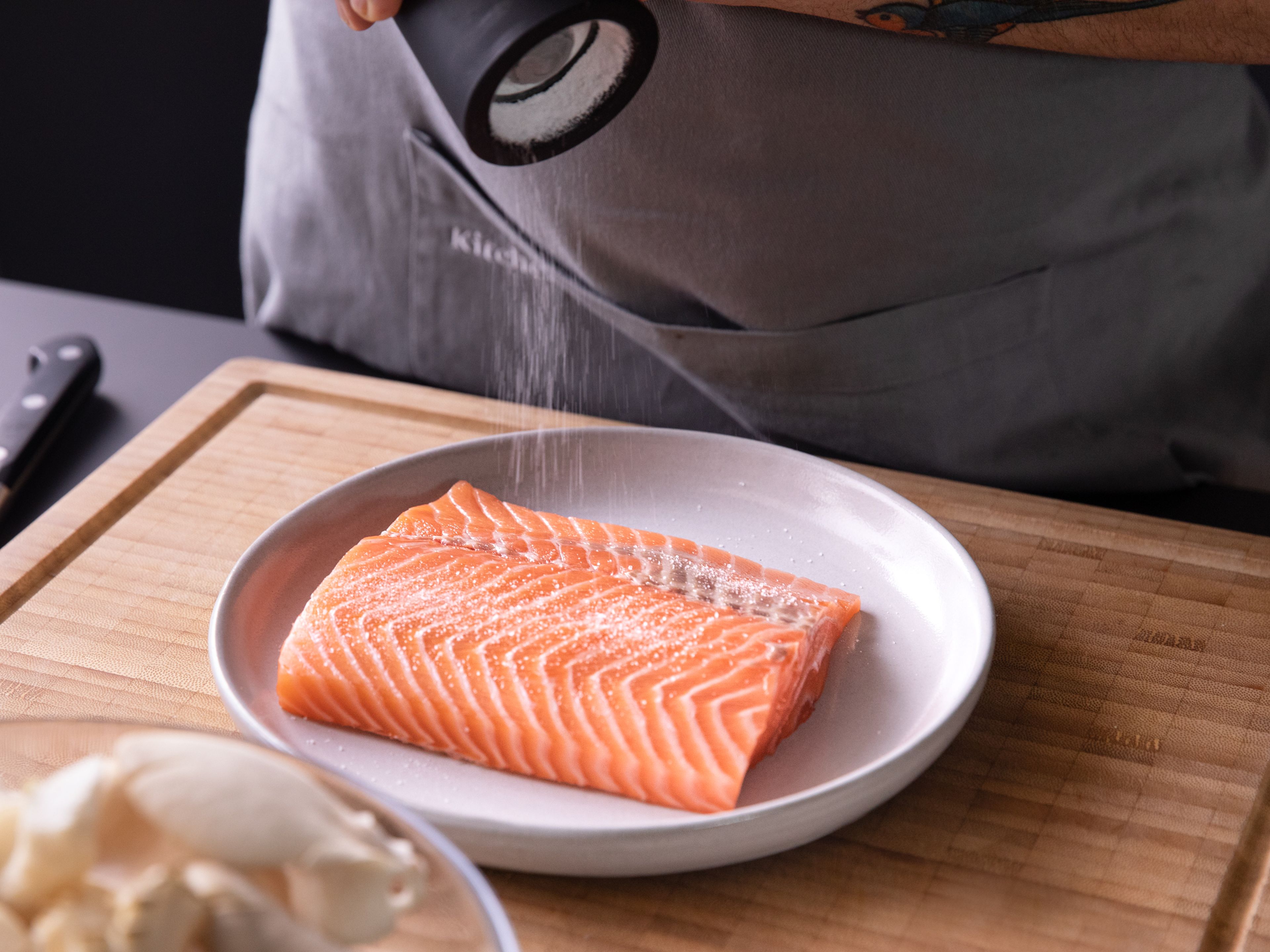 Dab salmon dry with paper towels and season with salt and pepper. Cut the puff pastry sheets into two squares and place on a parchment-lined baking sheet. Separate the egg yolk from the egg white and set aside.