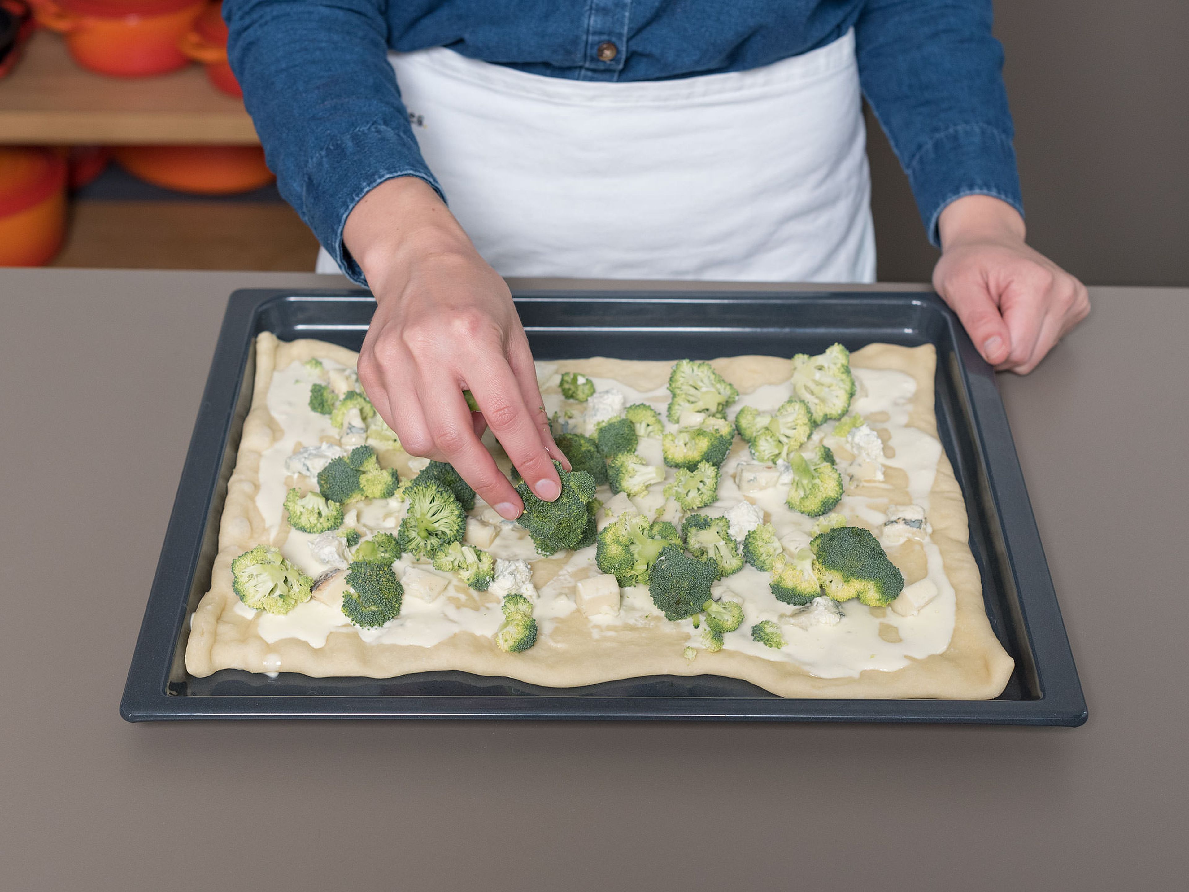Bake pizza dough in the oven on the lower rack for approx. 4 min., then remove from oven and allow to cool slightly. Spread mascarpone onto the dough, distribute broccoli and gorgonzola evenly on top, and sprinkle with chopped almonds.