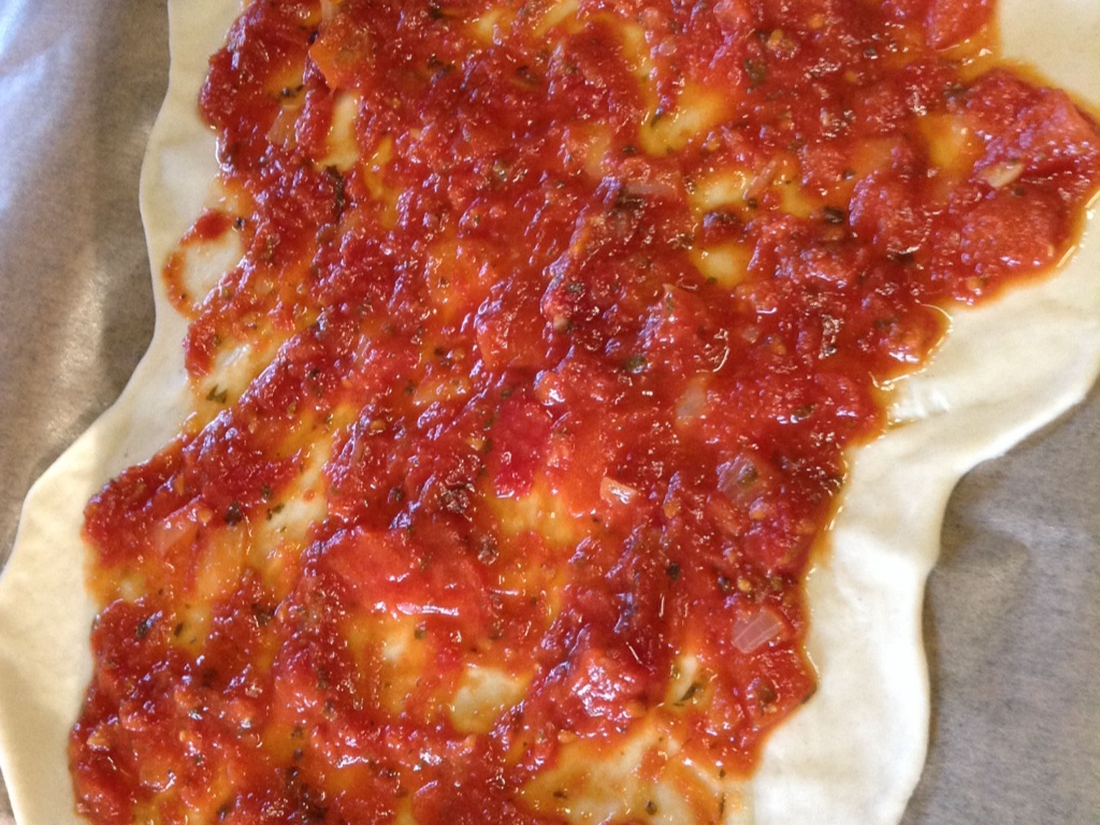 Cover dough with cold pizza sauce, leaving a 2-cm/0.8-in. thick crust. Make sure you don’t apply too much sauce or leave gaps. Use more or less sauce if required.