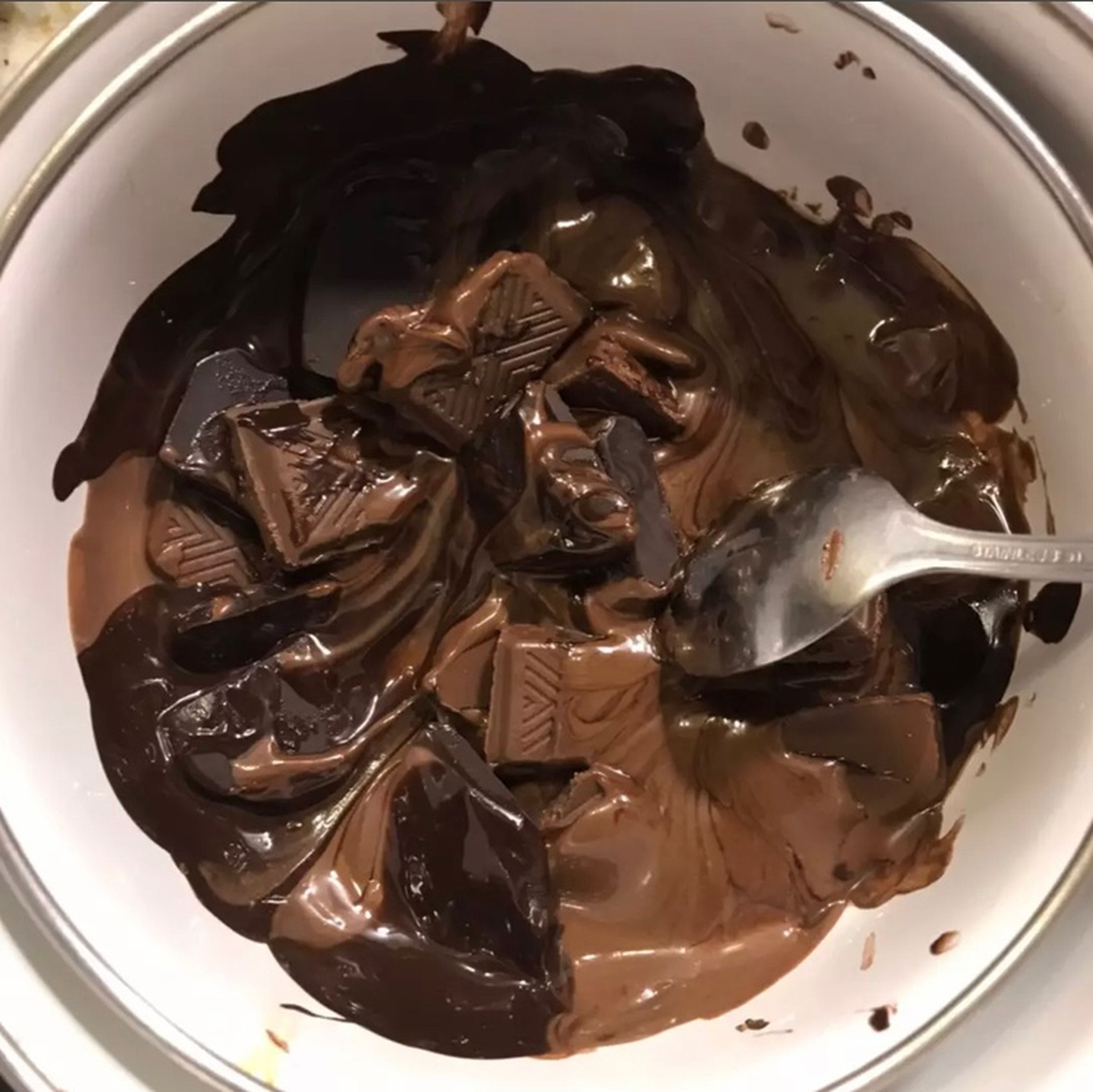 Pour a little water in a metal container and put it on a low flame to heat. Then we take a smaller metal container and pour the sliced chocolate on it. Put it in a bowl of hot water and melt it using the Ben Marie method. Stir until smooth.