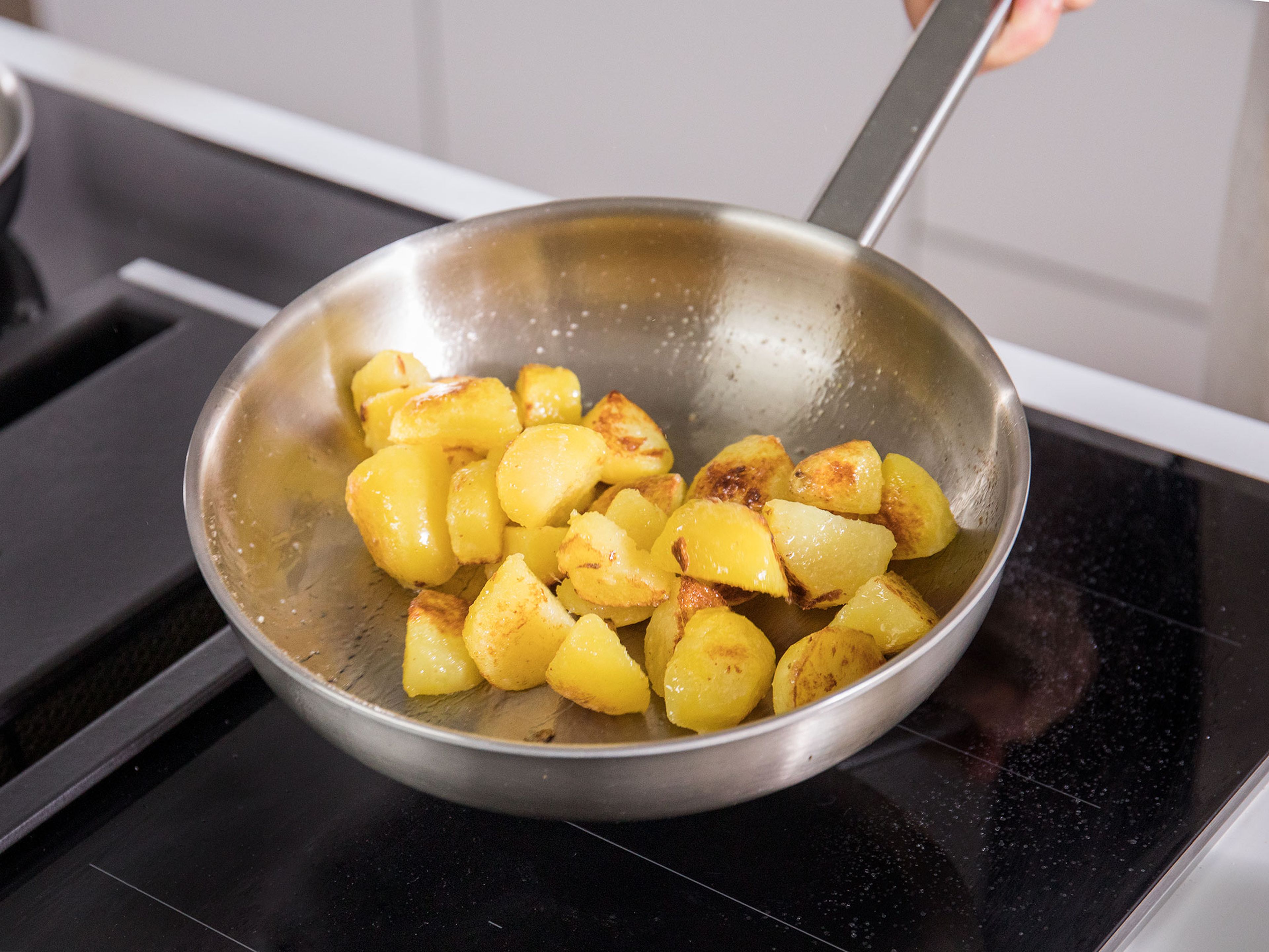 Kartoffeln abgießen, kurz abkühlen lassen, dann pellen. Pflanzenöl bei mittlerer Temperatur in einer Pfanne erhitzen und die Kartoffeln goldbraun rösten. Mit dem restlichen Zucker und etwas Salz würzen und beiseitestellen.