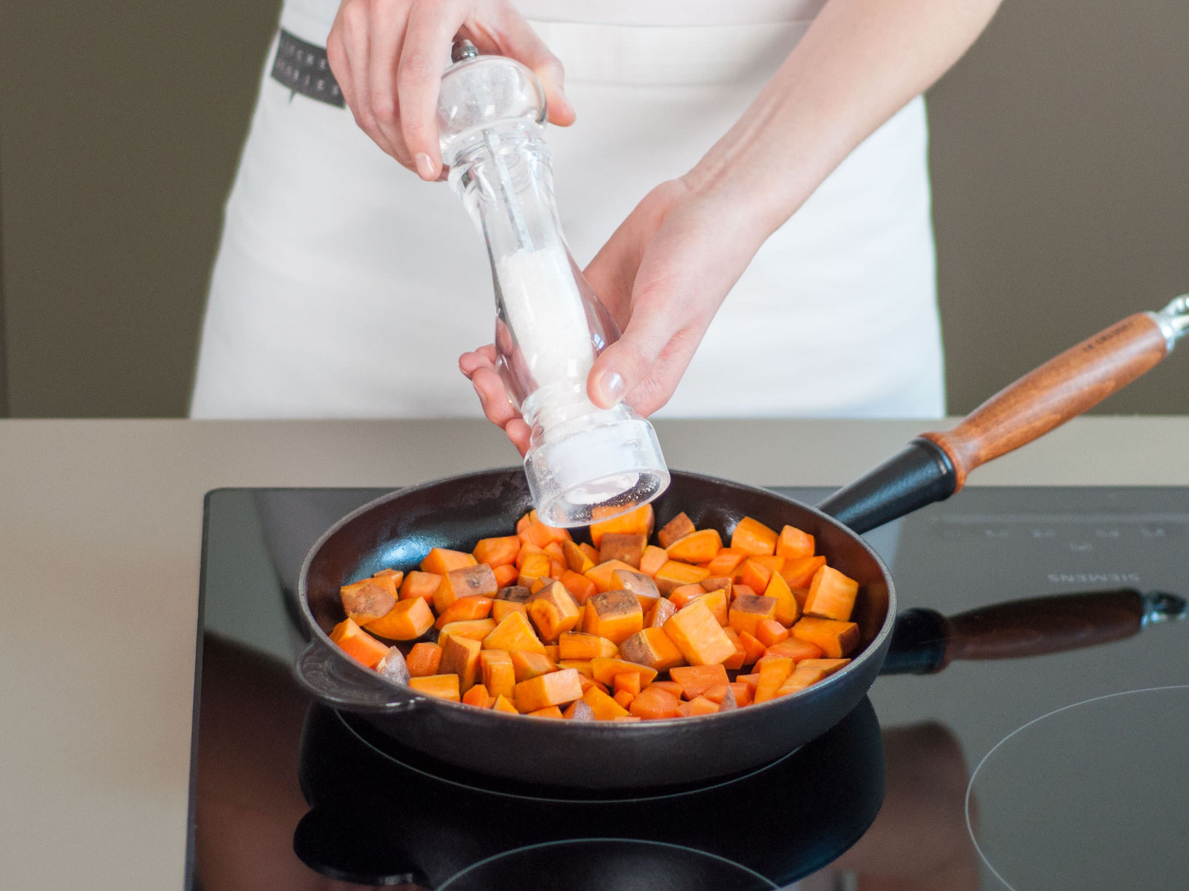 Süßkartoffelwürfel in einer großen Pfanne bei mittlerer Hitze für ca. 6 - 10 Min. goldbraun anbraten. Karotten hinzugeben und für weitere ca. 3 - 5 Min. anbraten.