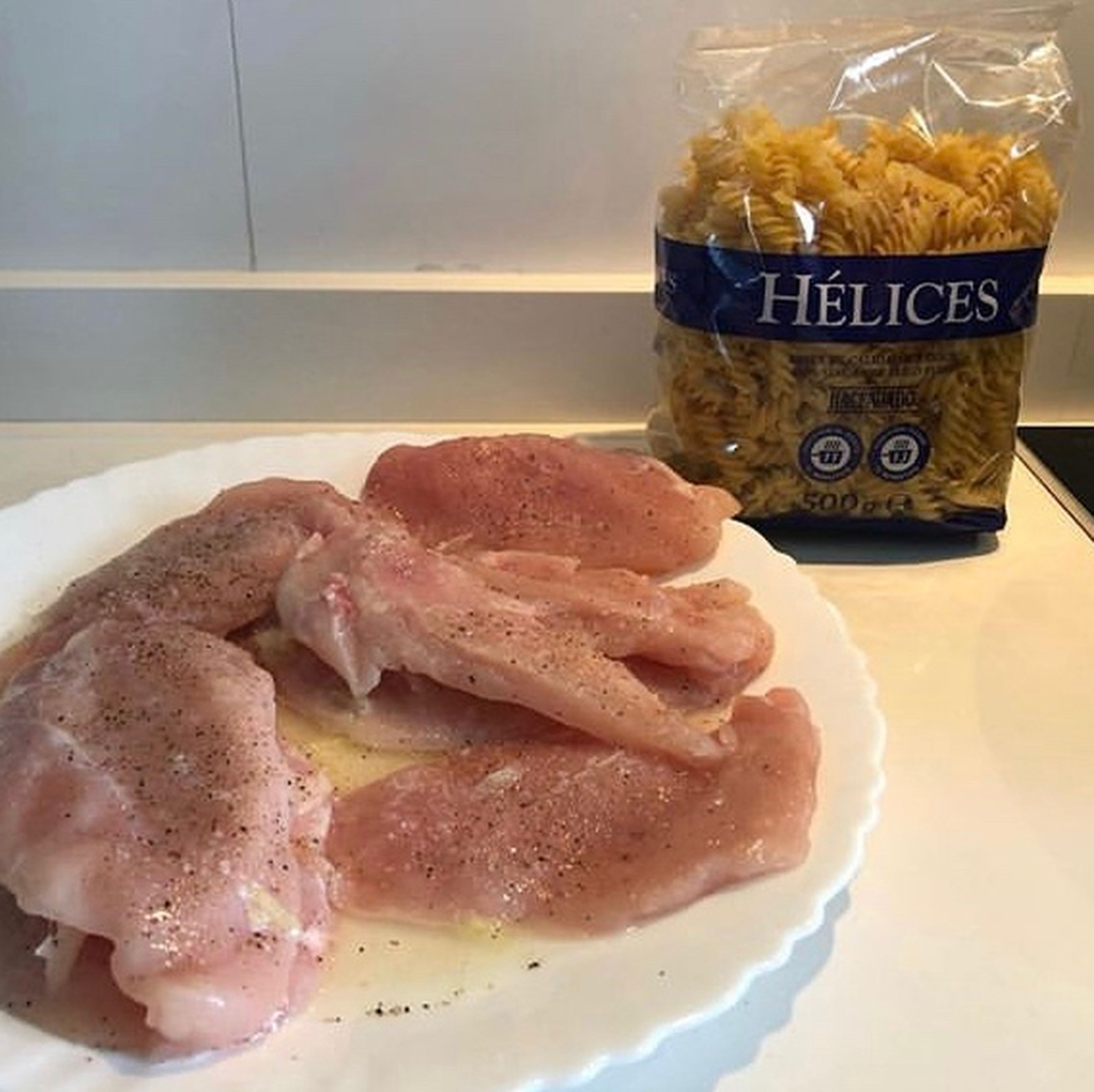 First thing first we are going to marinate the chicken by grabbing a plate and setting the thin chicken breast slices. Then add some lemon juice from the two full lemons. Season the chicken with salt and pepper and let it sit for 15 minutes.