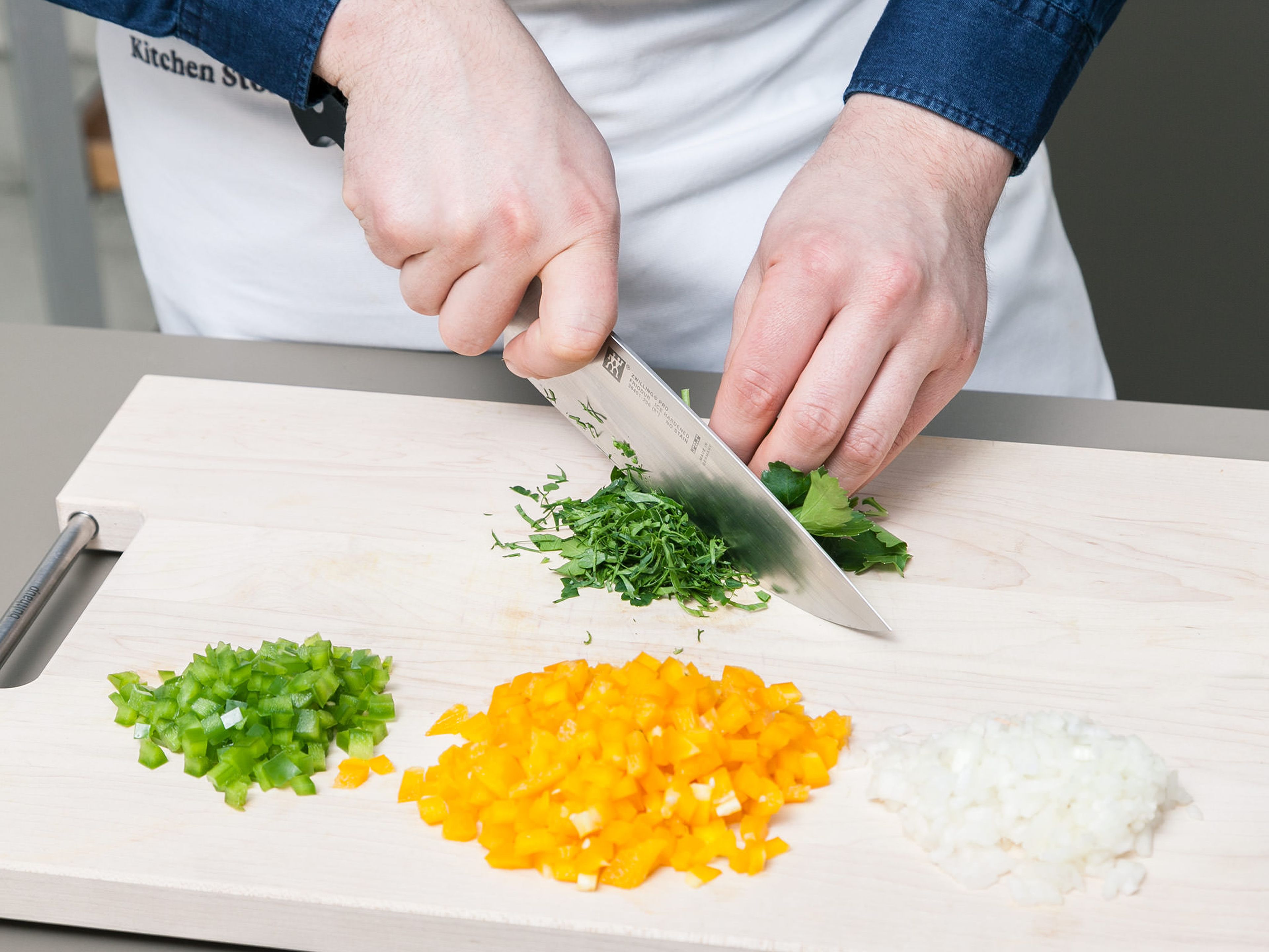 Peel and mince onion. Wash yellow and green bell pepper, remove seeds and finely dice. Pluck parsley leaves from the stems and finely chop.