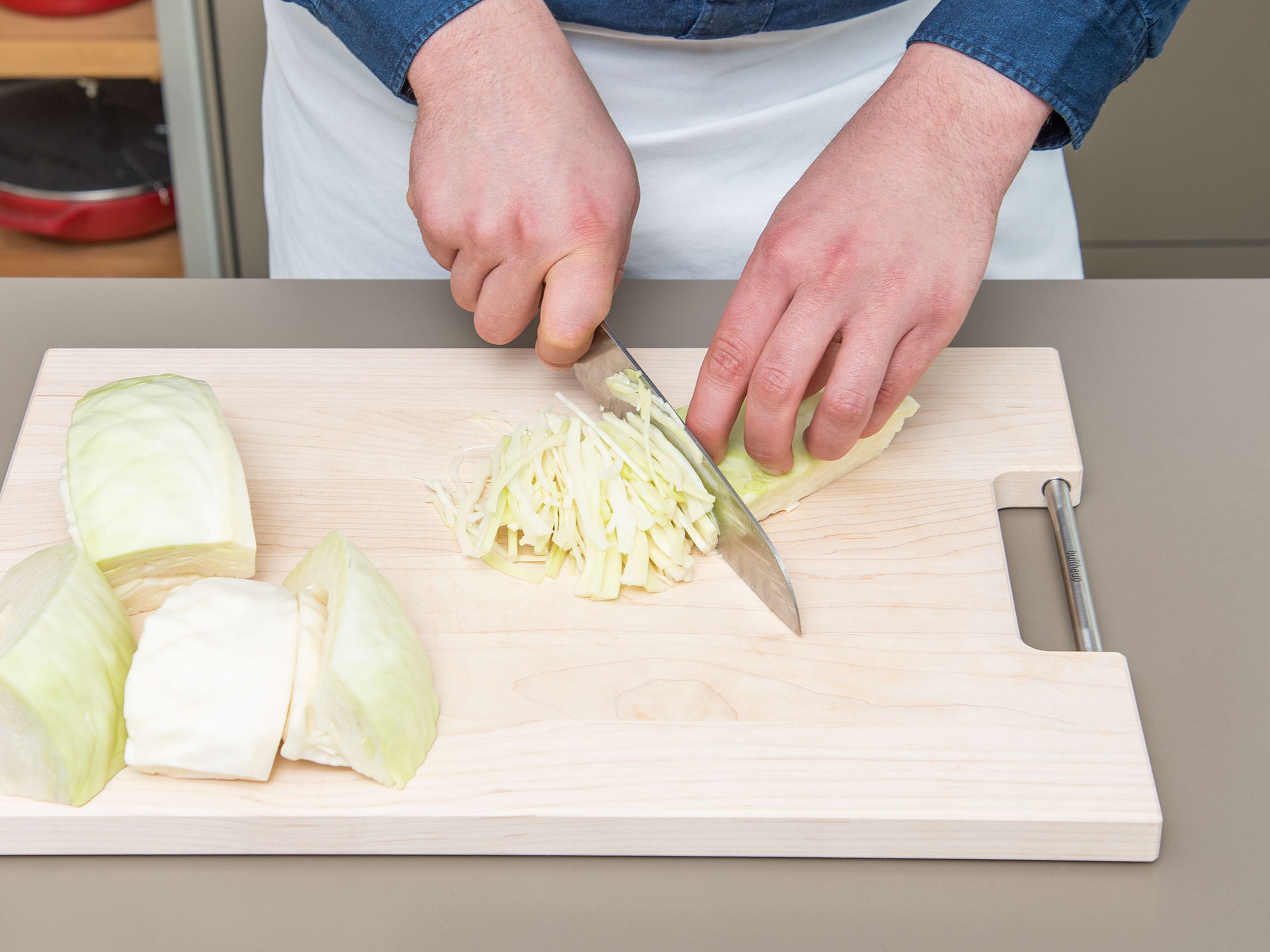 Clean and quarter white cabbage. Make a cut to remove the stem. Slice the white cabbage thin and add to a large bowl.