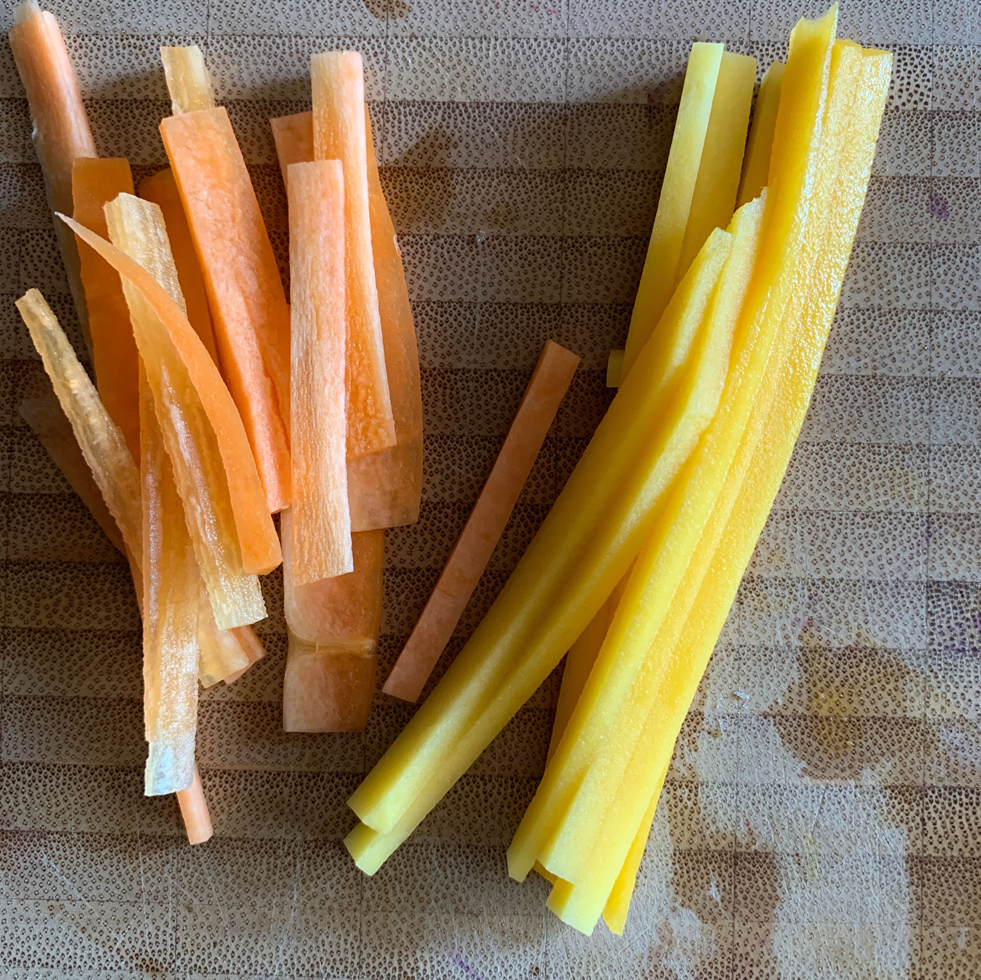 Karotten und Mango schälen und beides in feine Stifte schneiden