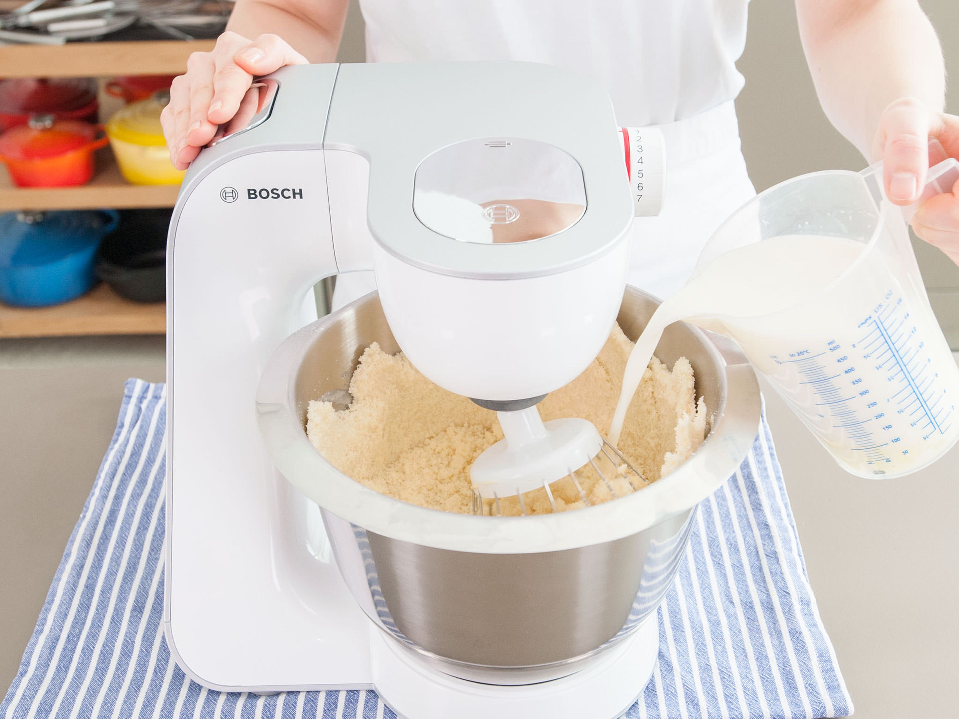 Mehl, Zucker, Backpulver und Salz auf niedriger Geschwindigkeitsstufe in der Küchenmaschine vermischen und nach und nach einen Teil der weichen Butter hinzufügen bis eine krümelige Masse entstanden ist. Die Hälfte der Milch-Ei-Mischung hinzugeben und bei mittlerer Geschwindigkeit für ca. 2 Min. verrühren. Übrige Milch-Ei-Mischung dazugeben und für eine weitere Minute verrühren. Überschüssigen Teig von den Rändern der Schüssel kratzen. Anschließend ca. 30 Sek. zu einer cremigen Masse schlagen.