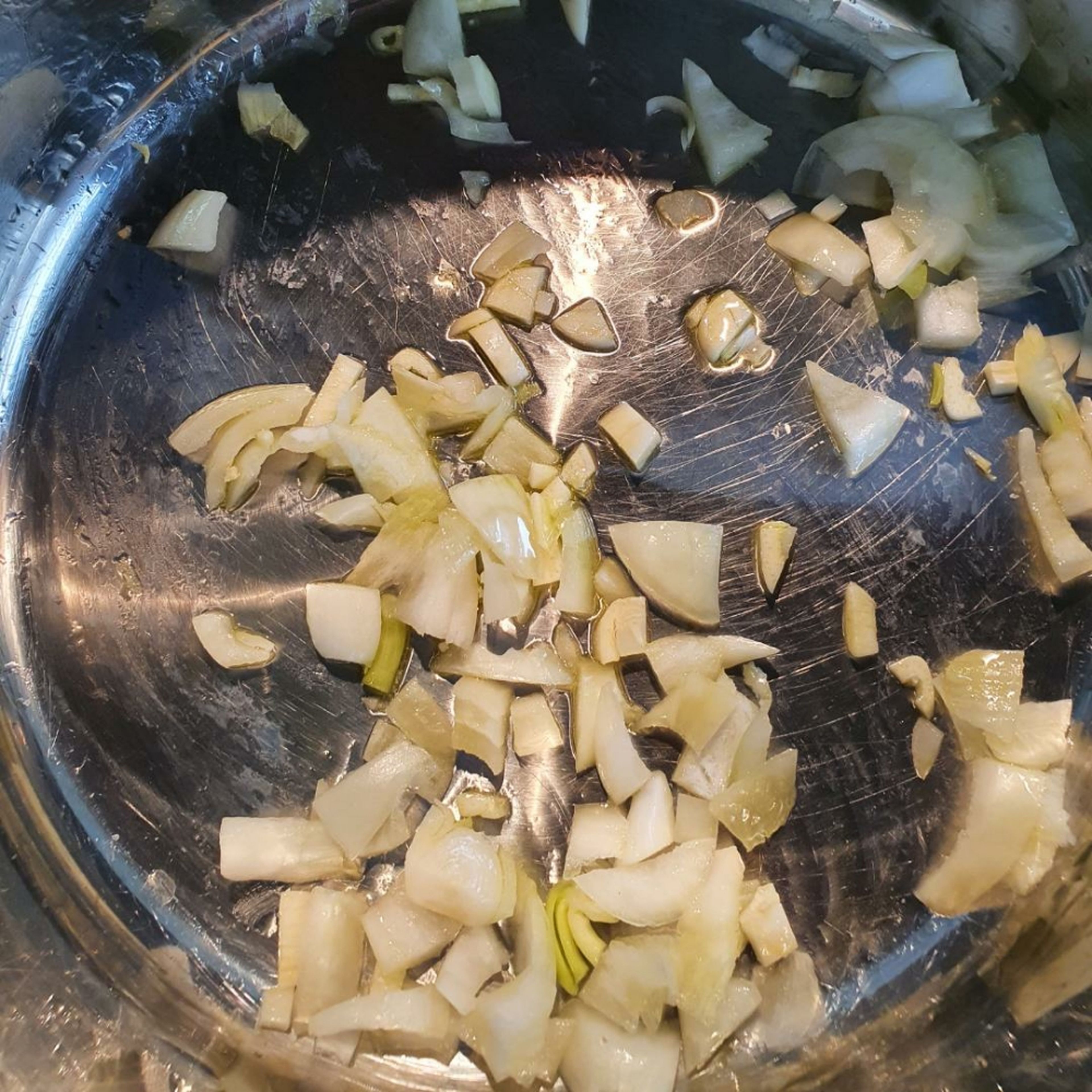 Die Zwiebeln und den Knoblauch schälen. Beides in kleine Stücke schneiden. Öl in einem großem Topf erhitzen und die Zwiebeln mit dem Knoblauch glasig andünsten.