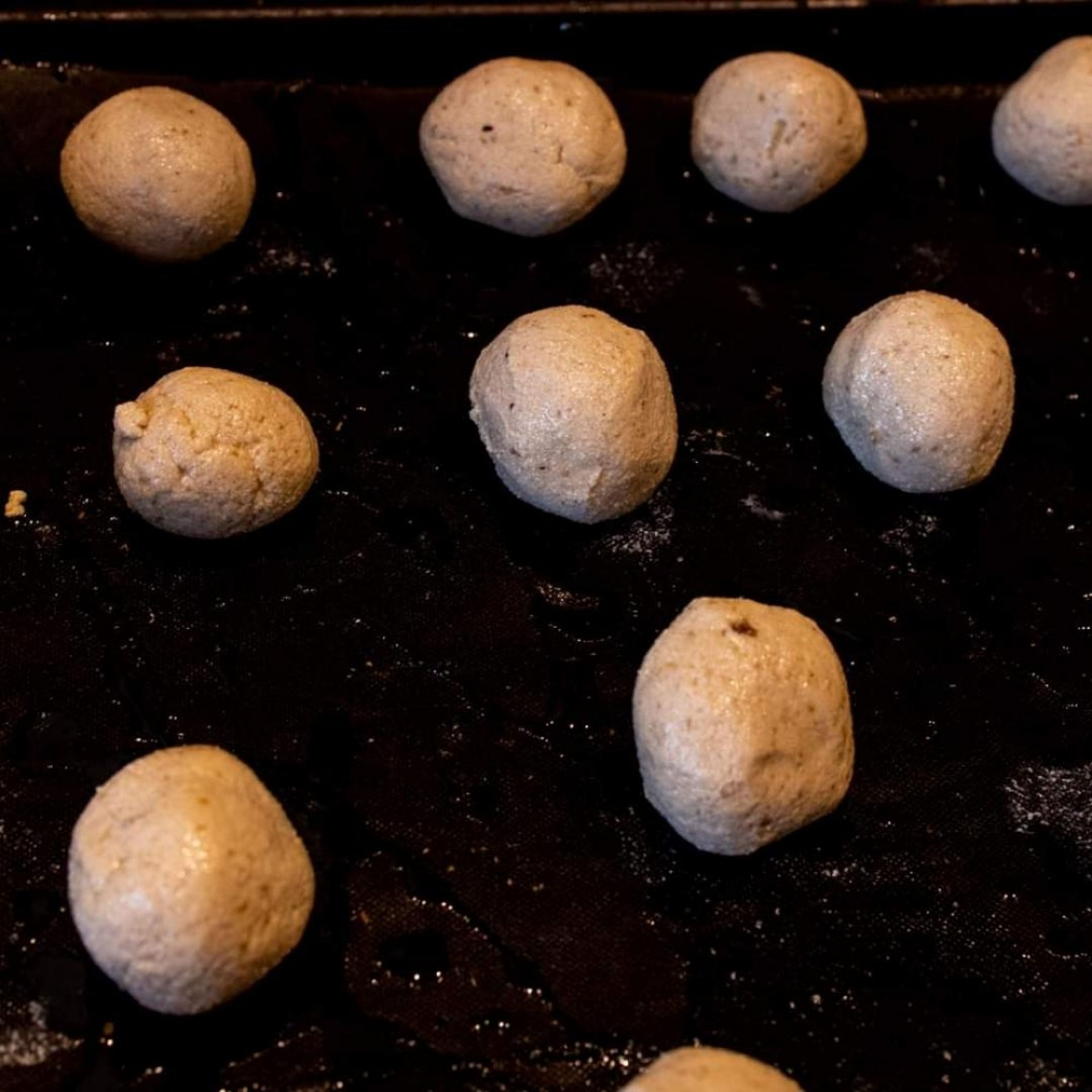 Aus der Masse mit angefeuchteten Händen Kugeln in Walnuss Größe formen. Aus ein Blech mit Backpapier legen, mit Öl beträufeln und für 30 Minuten ins Backrohr schieben ( mittlere Schiene ).