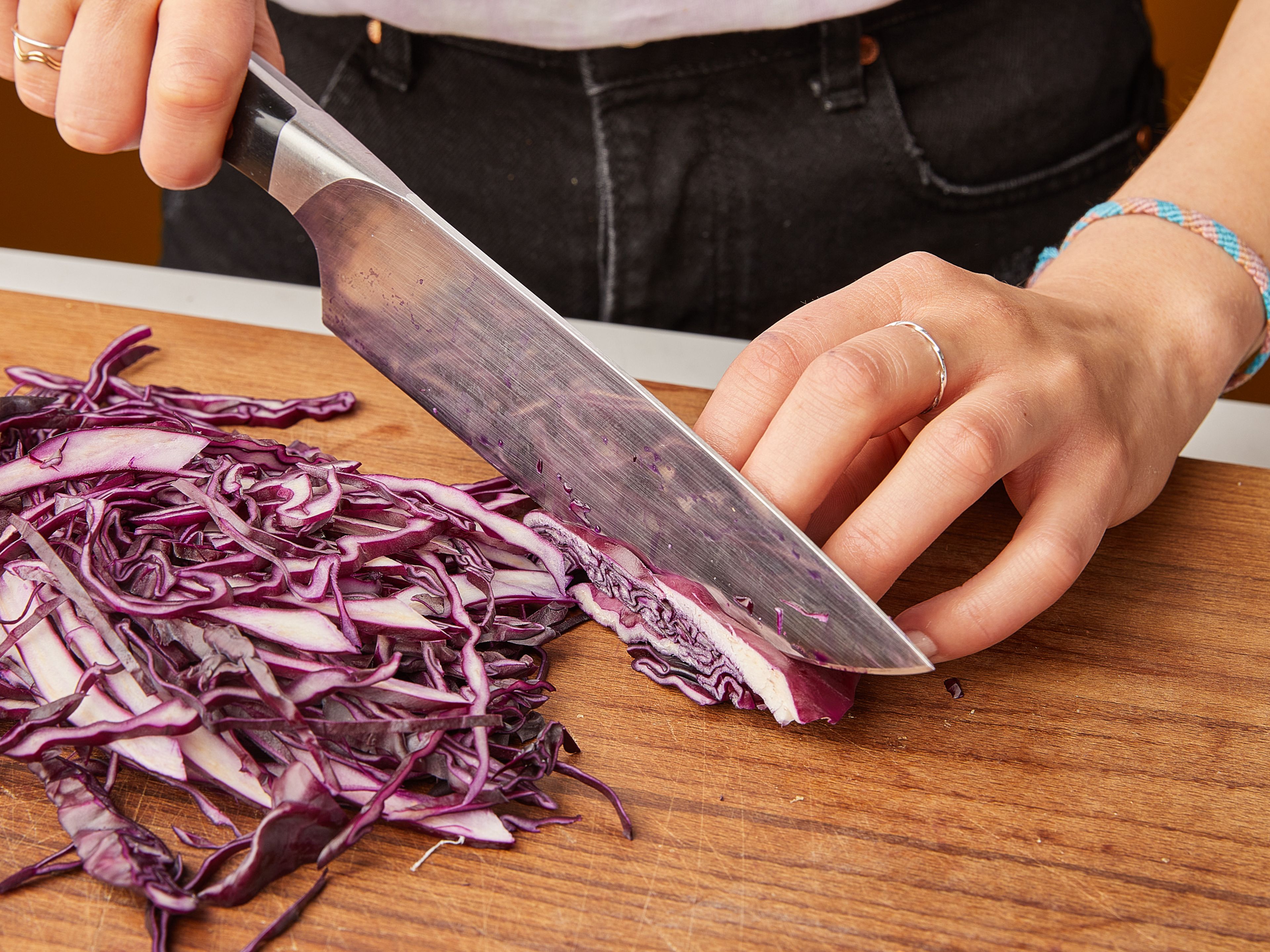 In the meantime, make the coleslaw: slice the red cabbage and carrots into thin strips. Slice the scallions into fine rings. In a large bowl, first mix the red cabbage with sesame oil, half of the mayonnaise, and white balsamic vinegar. Toss with your hands for about 1 min. until the cabbage gets softer. Then add the carrots and scallions, mix, and season with salt, pepper, and a little lime juice.