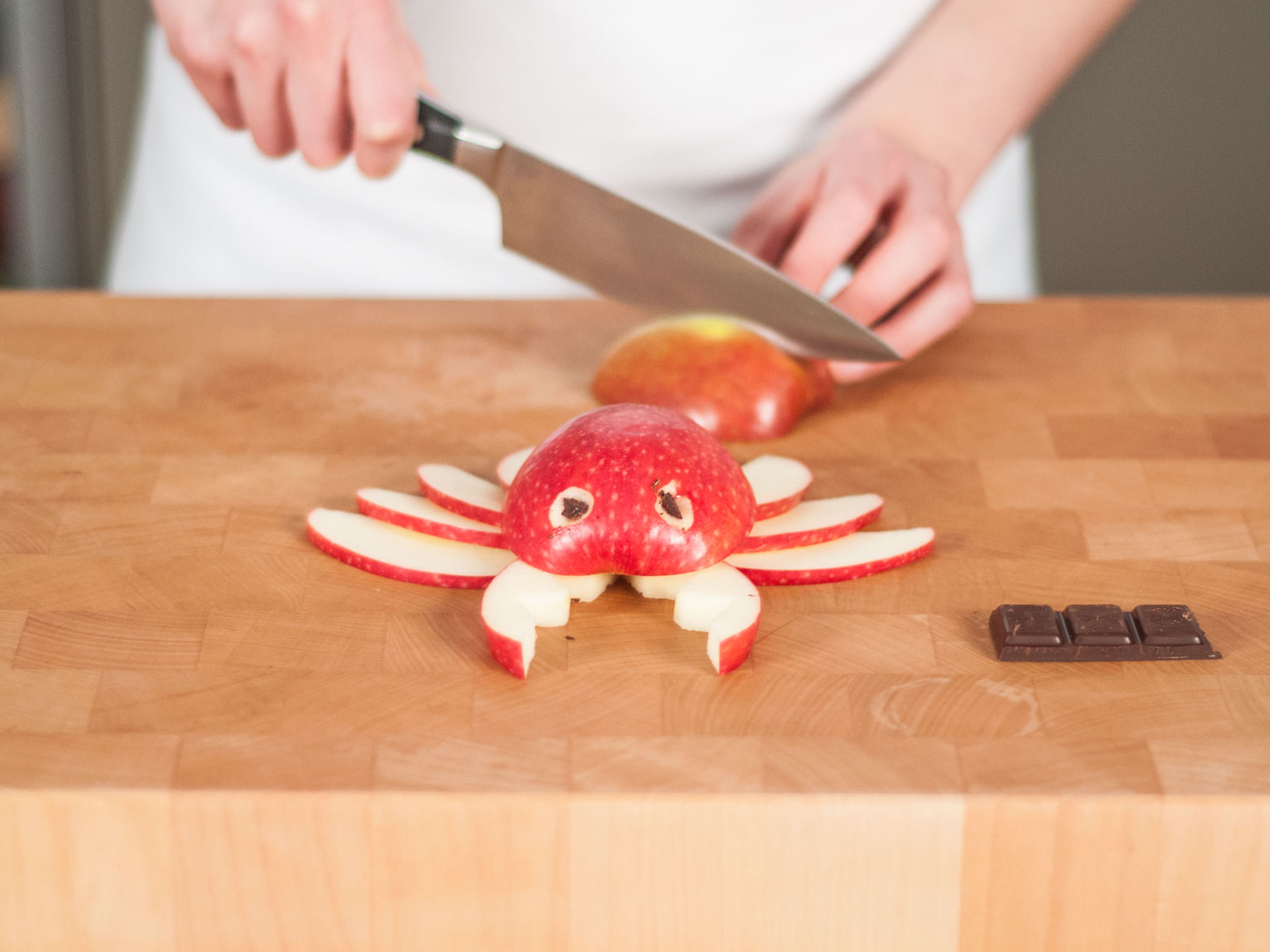 For the crab, halve one apple and cut out the core. Core and cut the other half into thin slices for legs, and cut serrated edges into two slices for the claws. Carve out small holes for the eyes, and stick small pieces of chocolate into the holes. If desired, use toothpicks to hold everything together.