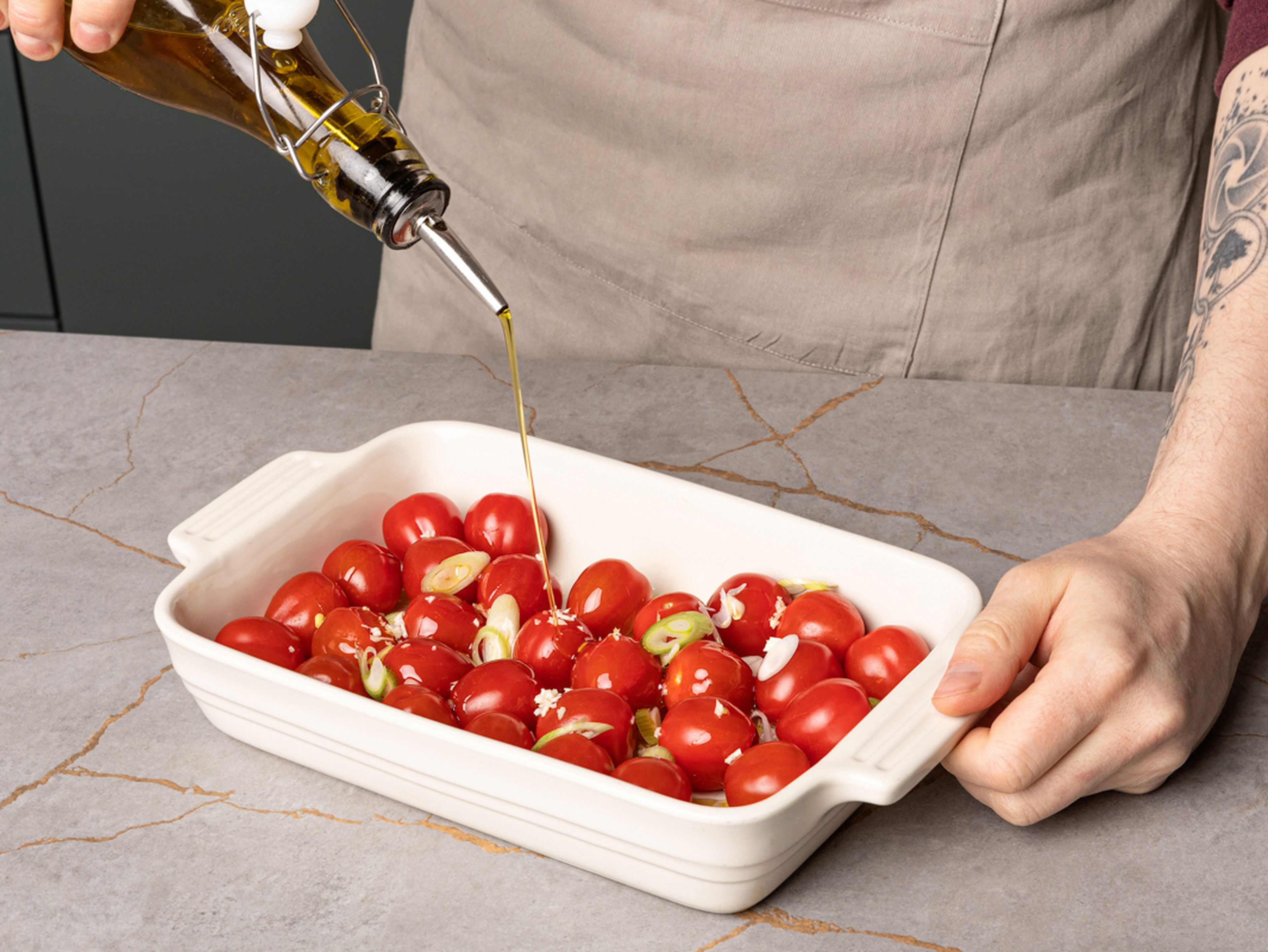 Place the cherry tomatoes in a baking dish and mix with the minced garlic, scallion whites and vegetable oil and season with salt. Bake in the preheated oven for approx. 15–18 min. until the tomatoes are softened and starting to burst open. Meanwhile, continue with the recipe.