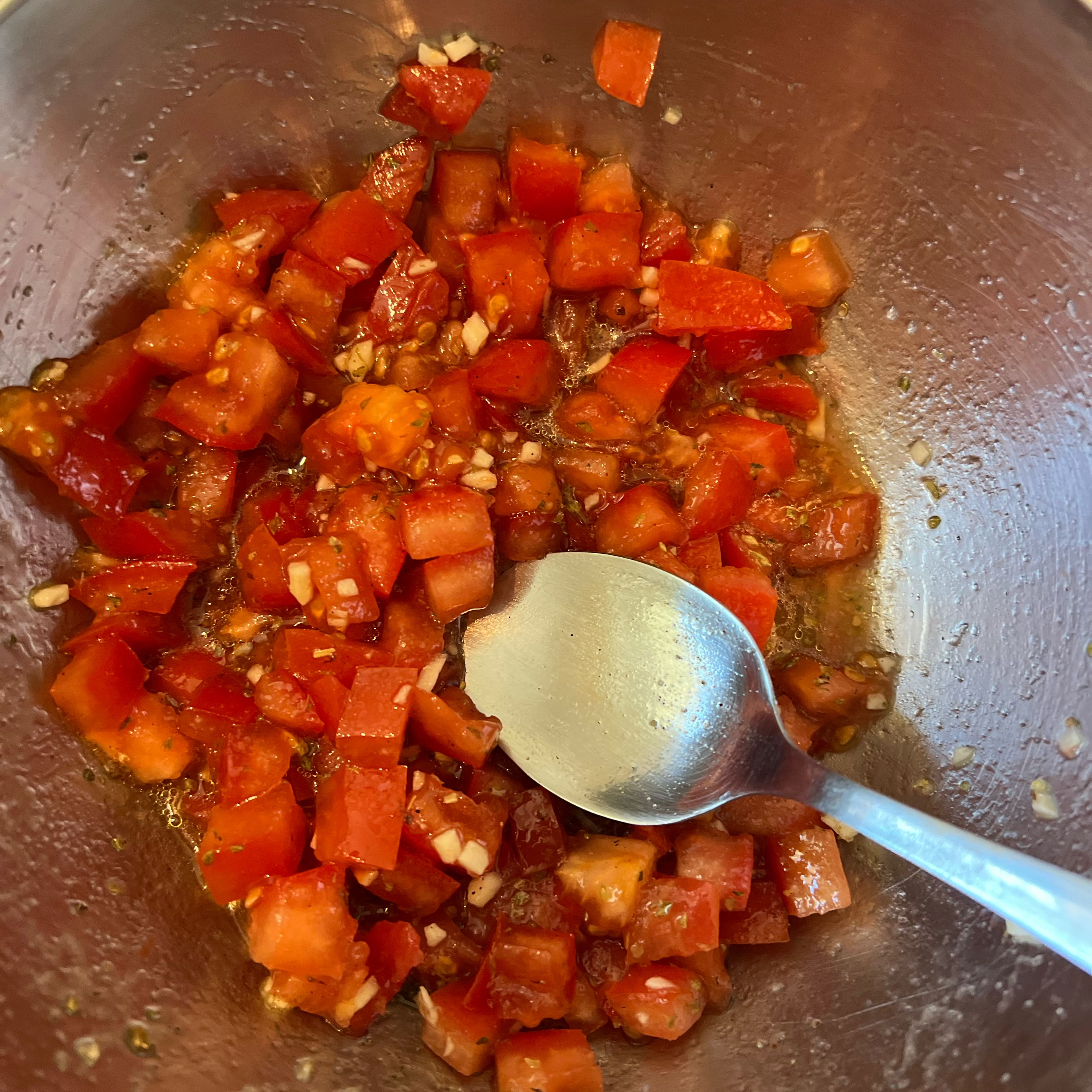 Tomaten- Knoblauchmischung mit Öl, Salz, Pfeffer und Oregano würzen