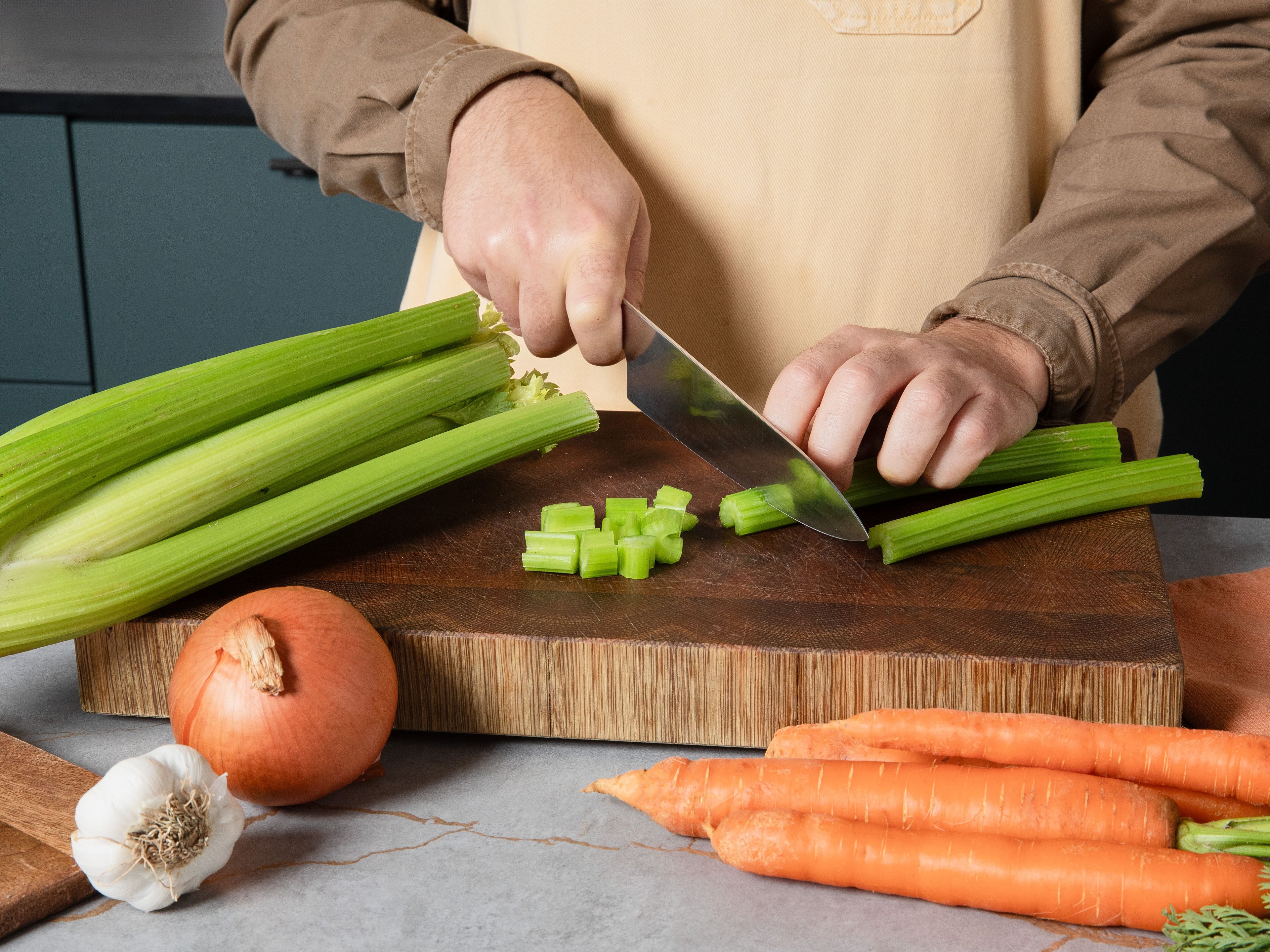 Das Rindergulasch  in eine Schüssel geben und mit Salz, Pfeffer und Mehl vermengen, bis alles gleichmäßig überzogen ist. Zwiebel und Karotten schälen, zusammen mit dem Sellerie würfeln. Den Knoblauch ebenfalls schälen und fein hacken. In einem großen Schmortopf das Öl auf mittelhoher Stufe erhitzen. Fleisch portionsweise rundum kräftig anbraten (je Seite ca. 2–3 Min.), dann herausnehmen und beiseitestellen.