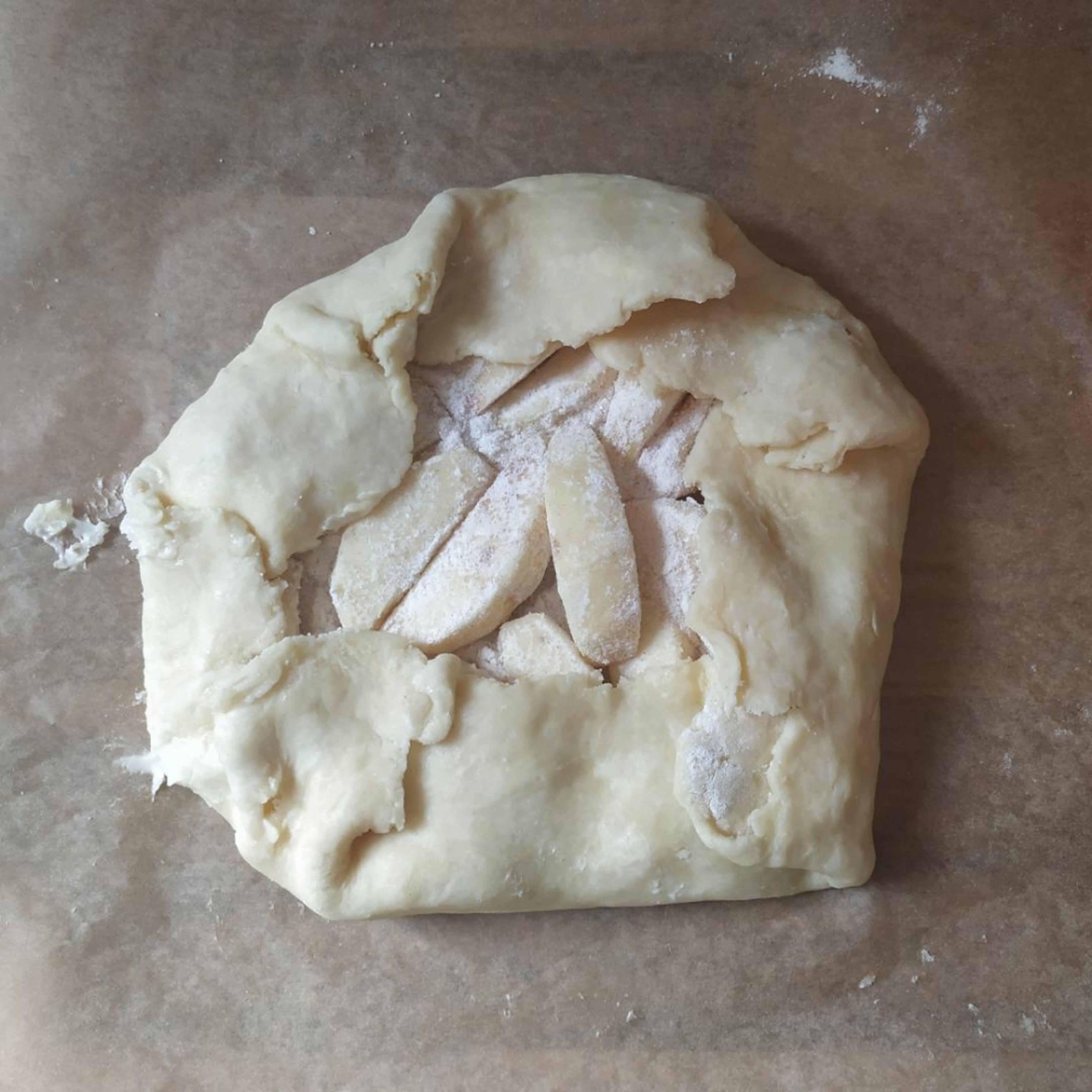 Die Ränder nach innen auf die Äpfel klappen. Die Crostata ca. 25-30 Minuten backen bis sie goldbraun ist.