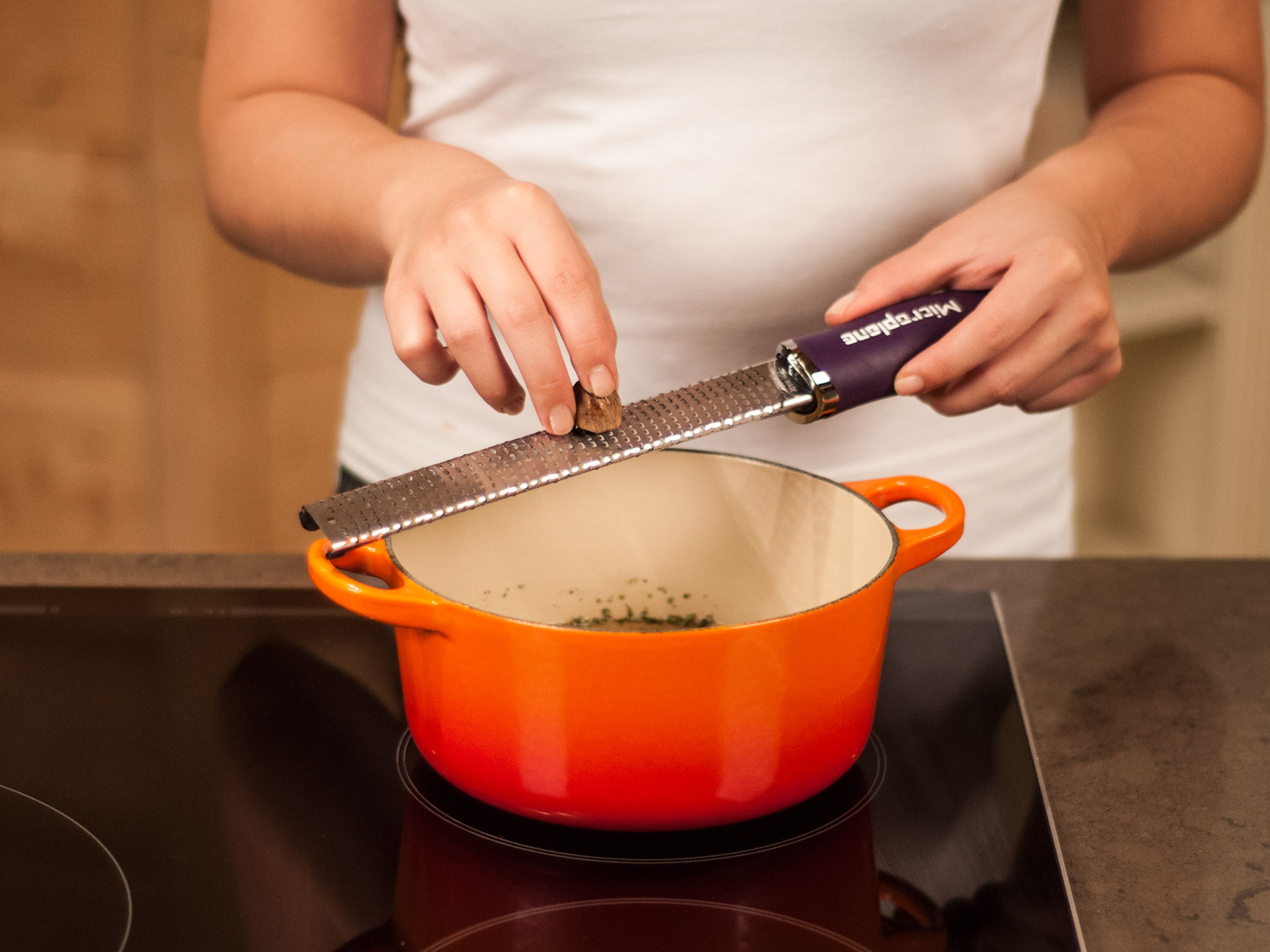 Hühnerbrühe und Rosmarinblätter in einen Topf geben, bei mittlerer Hitze erwärmen und mit Salz und Pfeffer abschmecken. Muskatnuss hineinreiben und aufkochen.
