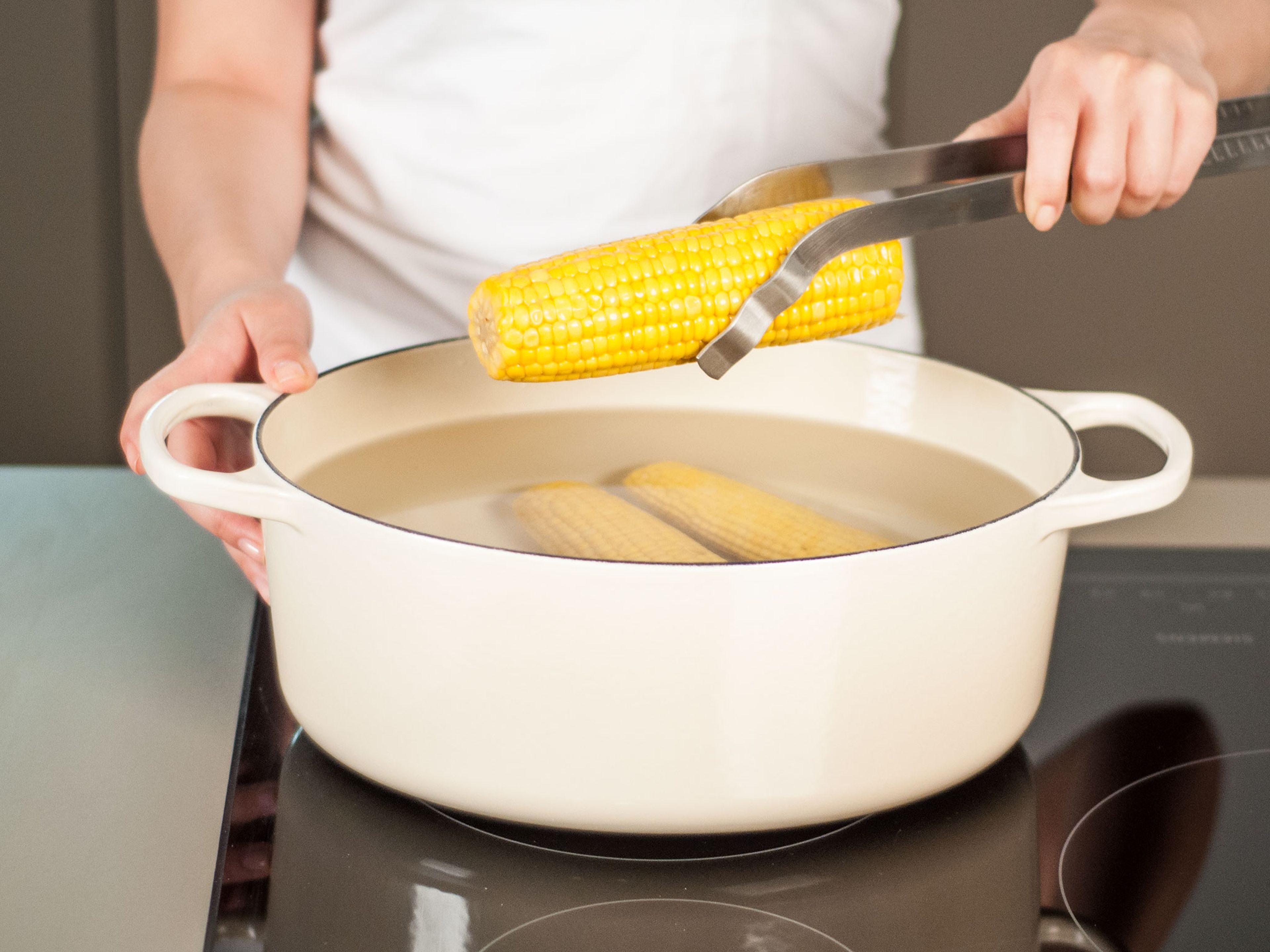 Maiskolben in einem großen Topf in gesalzenem, kochendem Wasser für ca. 5 – 10Min. kochen lassen. Abgießen und zur Seite stellen.