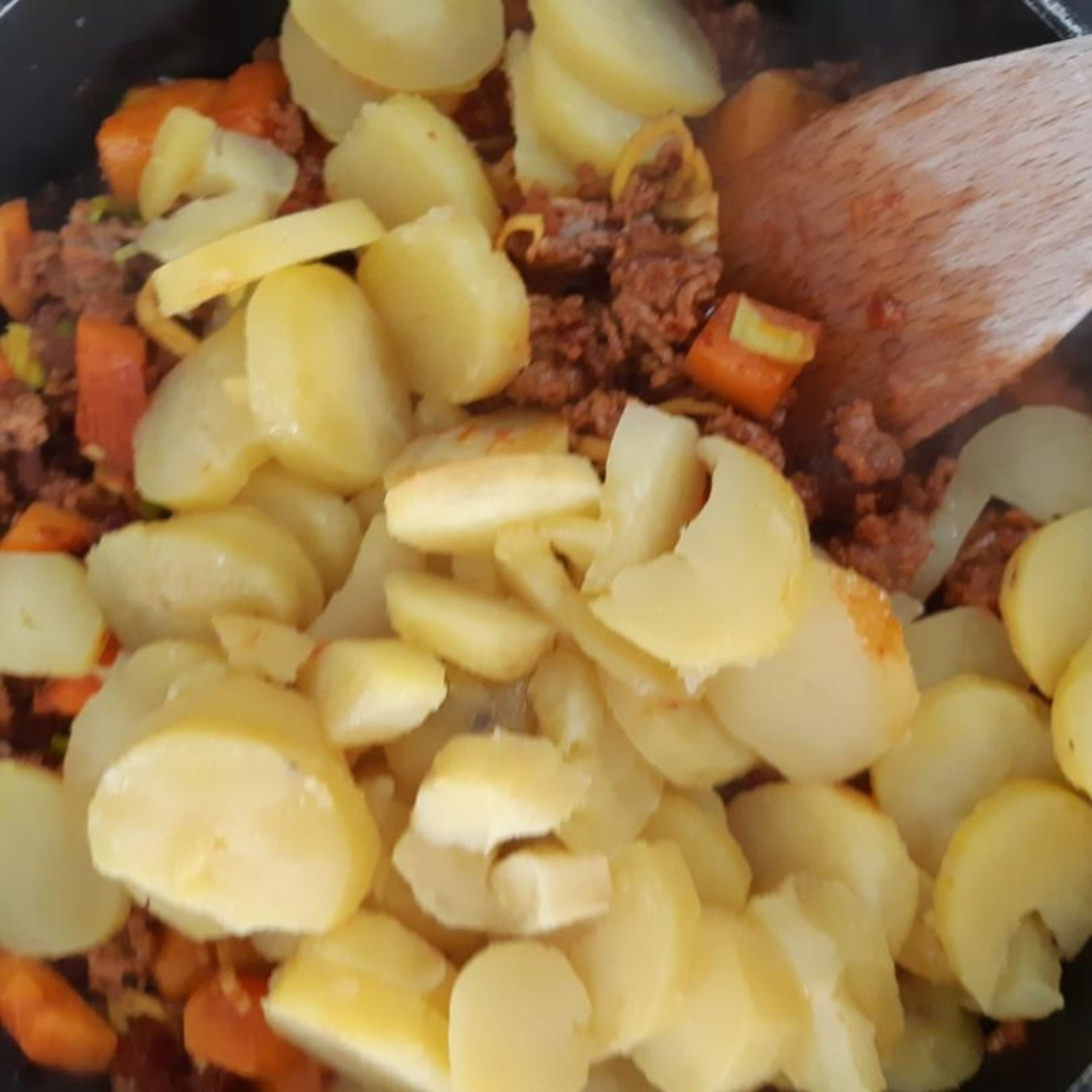 Kartoffeln abseihen, schälen und in Scheibenbremsen schneiden. Danach in die Hackfleisch-Gemüse-Masse geben.