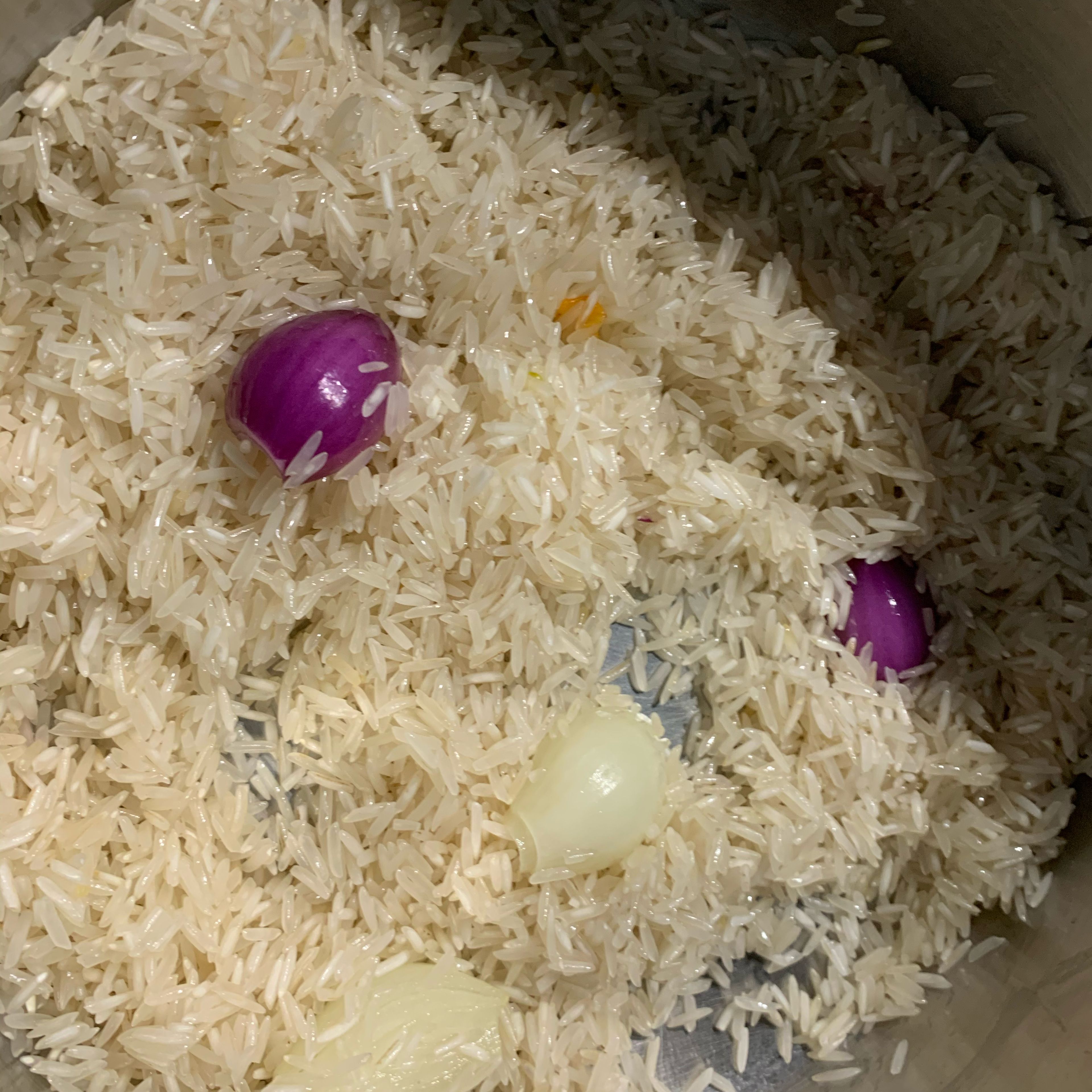 Während das Gemüse brät, den Reis zunächst waschen und etwas Sonnenblumenöl im Topf erwärmen. Wasser im Wasserkocher zum kochen bringen. Zwiebeln in den Topf legen und den Reis dazu geben. Alles für 2-3 Minuten etwas anrösten lassen, jedoch aufpassen, dass der Reis nicht verbrennt. Anschließend das Wasser darüber geben, das Gemüsebrühe-Pulver hinzugeben und den Reis ca. 10 Minuten köcheln lassen. Wenn er fertig gegart ist, das Wasser abschütten.
