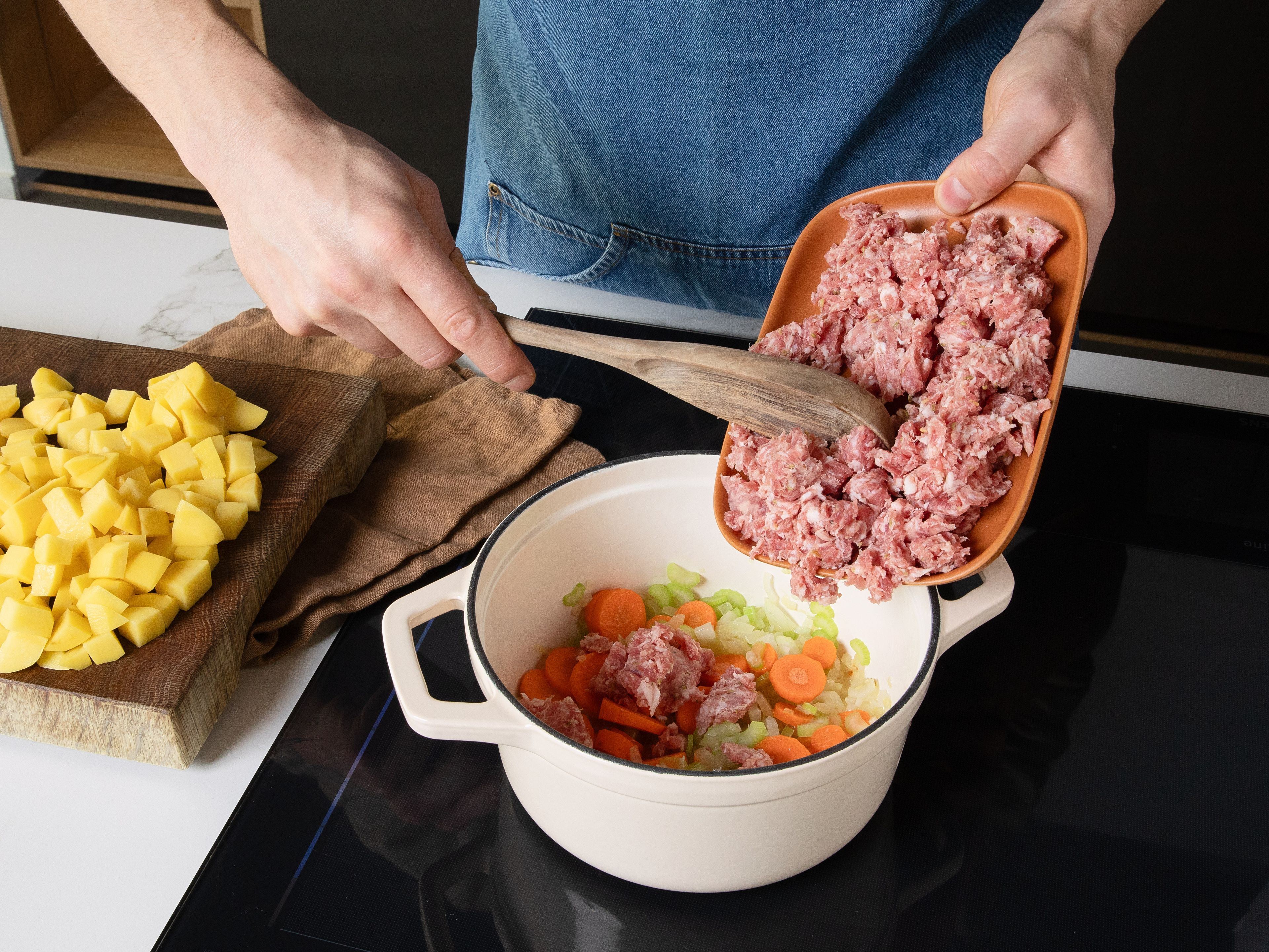 Salsiccia aus der Pelle nehmen, klein zerbröseln und zu dem Gemüse in den Topf geben. Alles unter Rühren ca. 5–7 Min. anbraten, bis die Wurst leicht gebräunt ist. Die Kartoffeln und die Gemüsebrühe hinzufügen. Aufkochen lassen und bei mittlerer Hitze ca. 15 Min. köcheln, bis die Kartoffeln weich sind. Währenddessen die dicken Stiele des Grünkohls entfernen und die Blätter in mundgerechte Stücke schneiden.