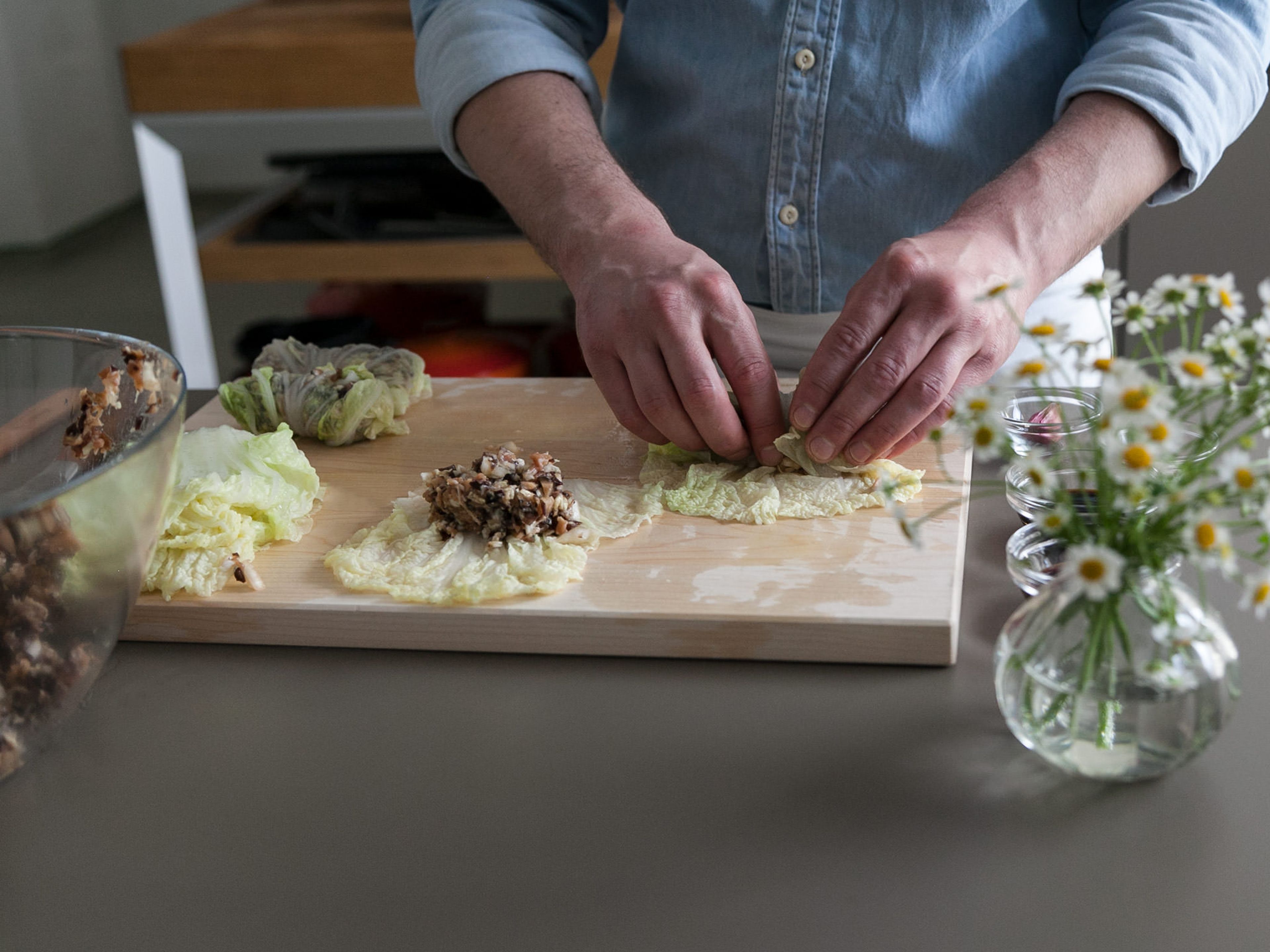 Smooth blanched cabbage leaves onto a clean work surface and place two spoons of filling on each leaf. Roll from the bottom up, folding in both sides in order to seal in the filling. If desired, fix with toothpicks. Repeat until all filling is used up.