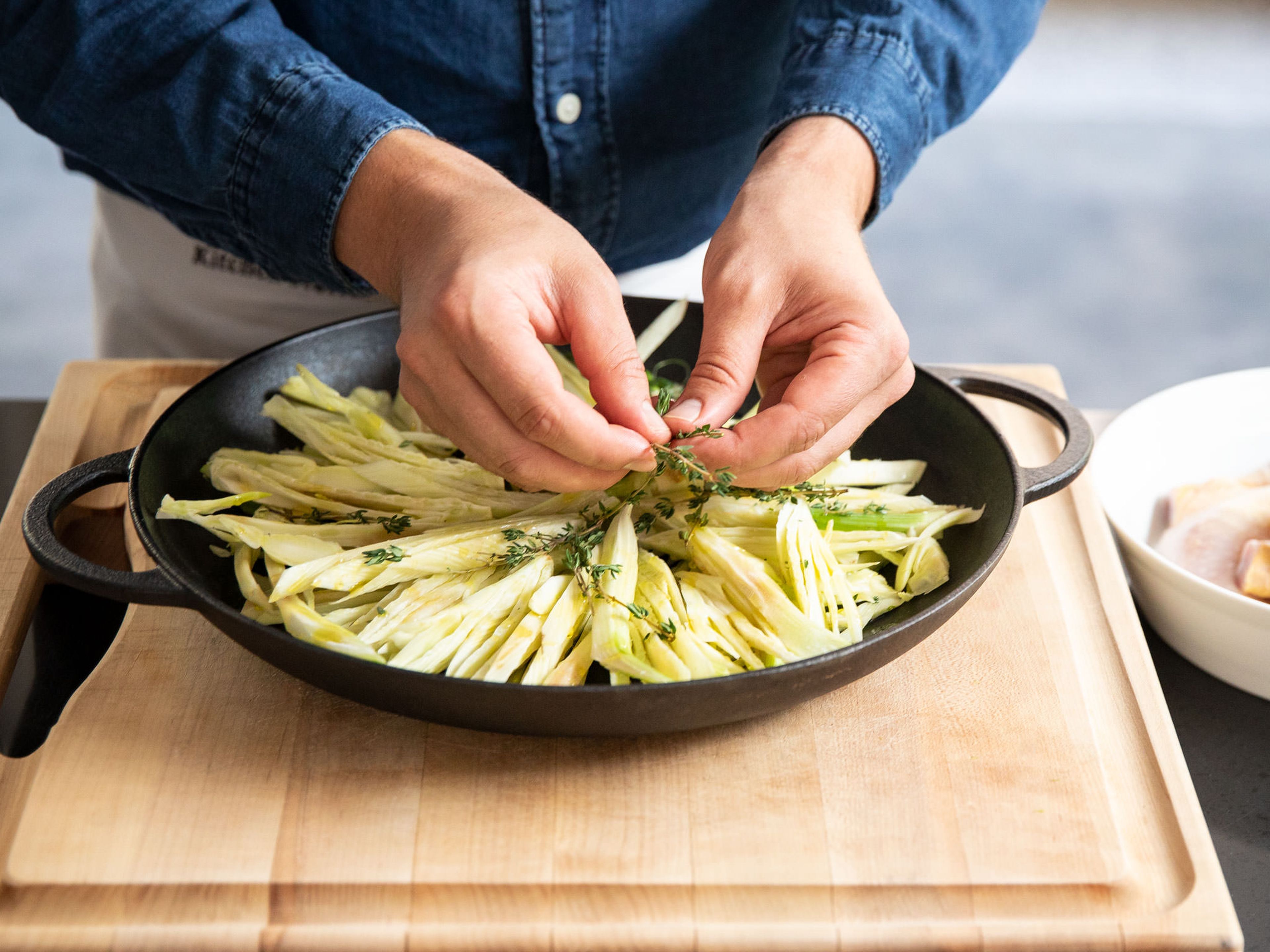 Cut off the ends of the fennel and slice finely. Transfer into a microwave proof baking dish. Drizzle with olive oil and scatter thyme on top. Season with salt and pepper and toss well.