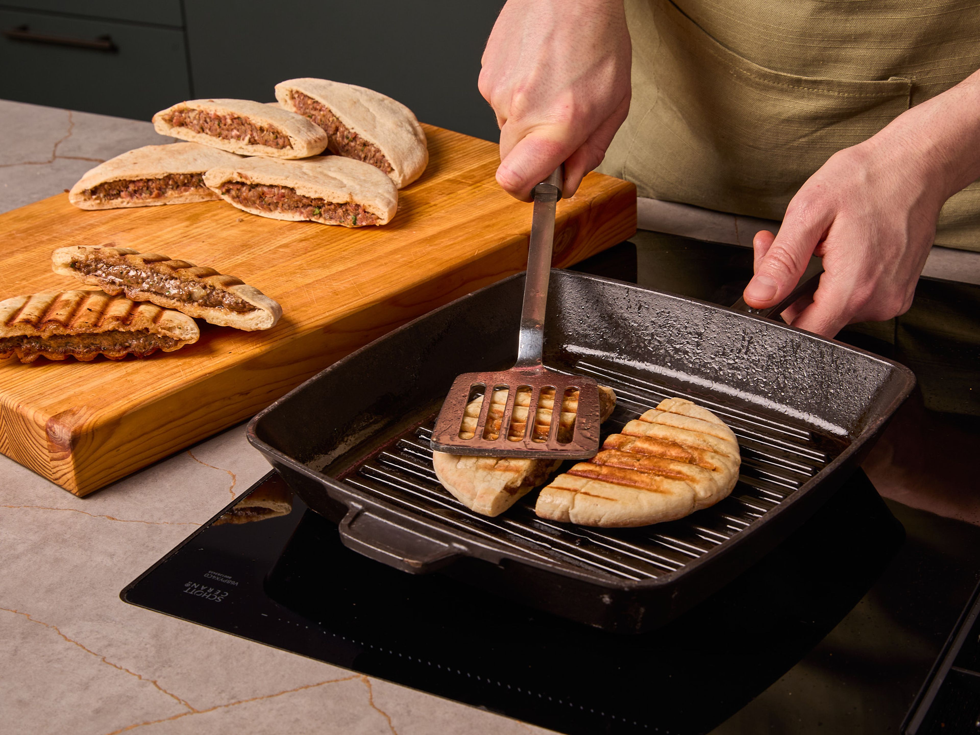 Etwas Olivenöl in einer großen Pfanne erhitzen. Die vorbereiteten Pita-Taschen in der Pfanne ca. 2–3 Min. pro Seite sowie auf der Schnittkante braten, dabei leicht mit einem Pfannenwender andrücken, bis sie goldbraun und knusprig sind.