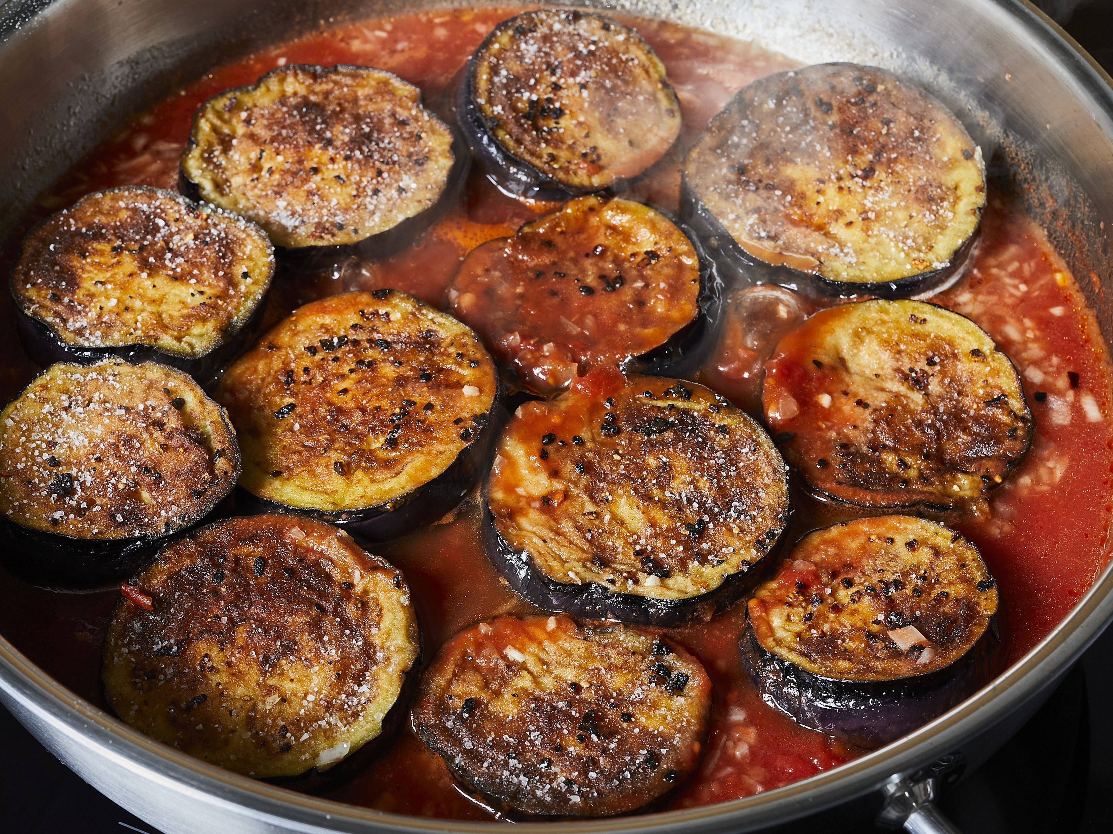 Return eggplant to the sauce in the pan and let simmer while covered for approx. 12 min. until eggplant is tender, turn it over once. Then remove the lid and let simmer for another 4–6 min. until the sauce is thick.