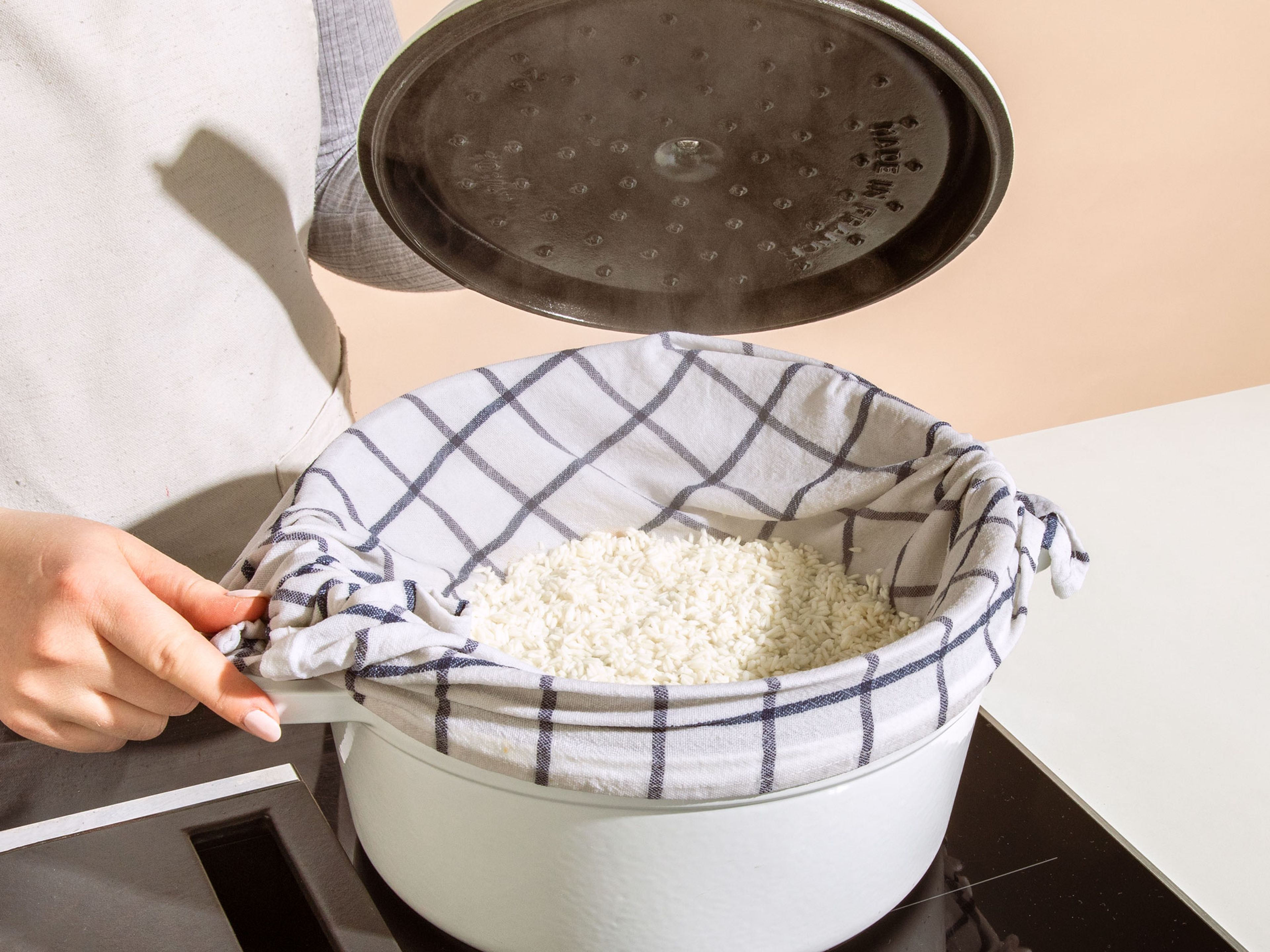 Jetzt den Reis in ein feines Sieb geben und nochmals mit Wasser abspülen. Einen großen Topf mit Wasser zum Kochen bringen und dann auf mittlere Hitze einstellen, sodass das Wasser leicht siedet. Das Sieb über den Topf hängen, wobei es nicht das Wasser berühren darf. Mit einem Deckel abdecken und den Reis für 30 Min. dämpfen.