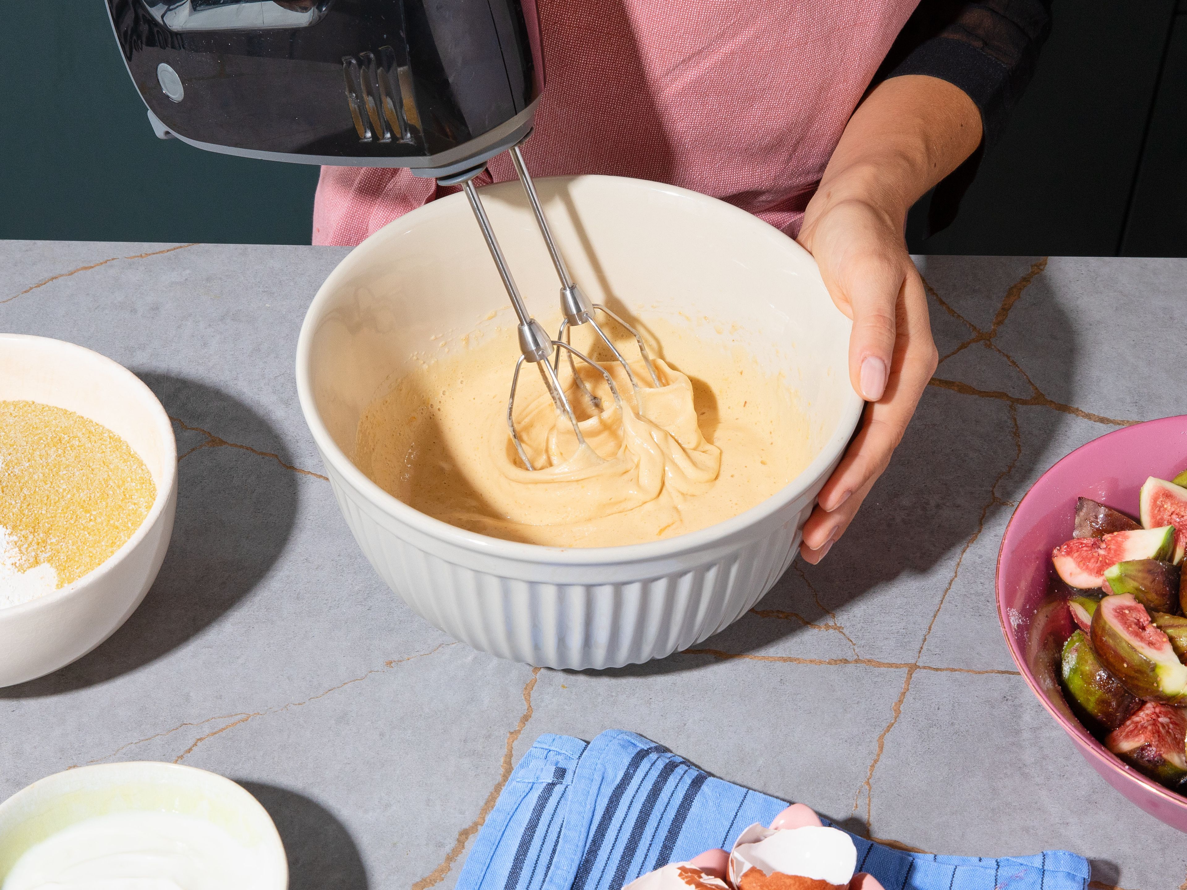In a large bowl, combine the flour, polenta, baking powder, and salt. In a second bowl, beat the brown and white sugar with the eggs until light and creamy. Briefly mix in the dry ingredients, then stir in the yogurt, melted butter, and oil until a smooth batter forms. Fold in approx. half of the marinated figs.