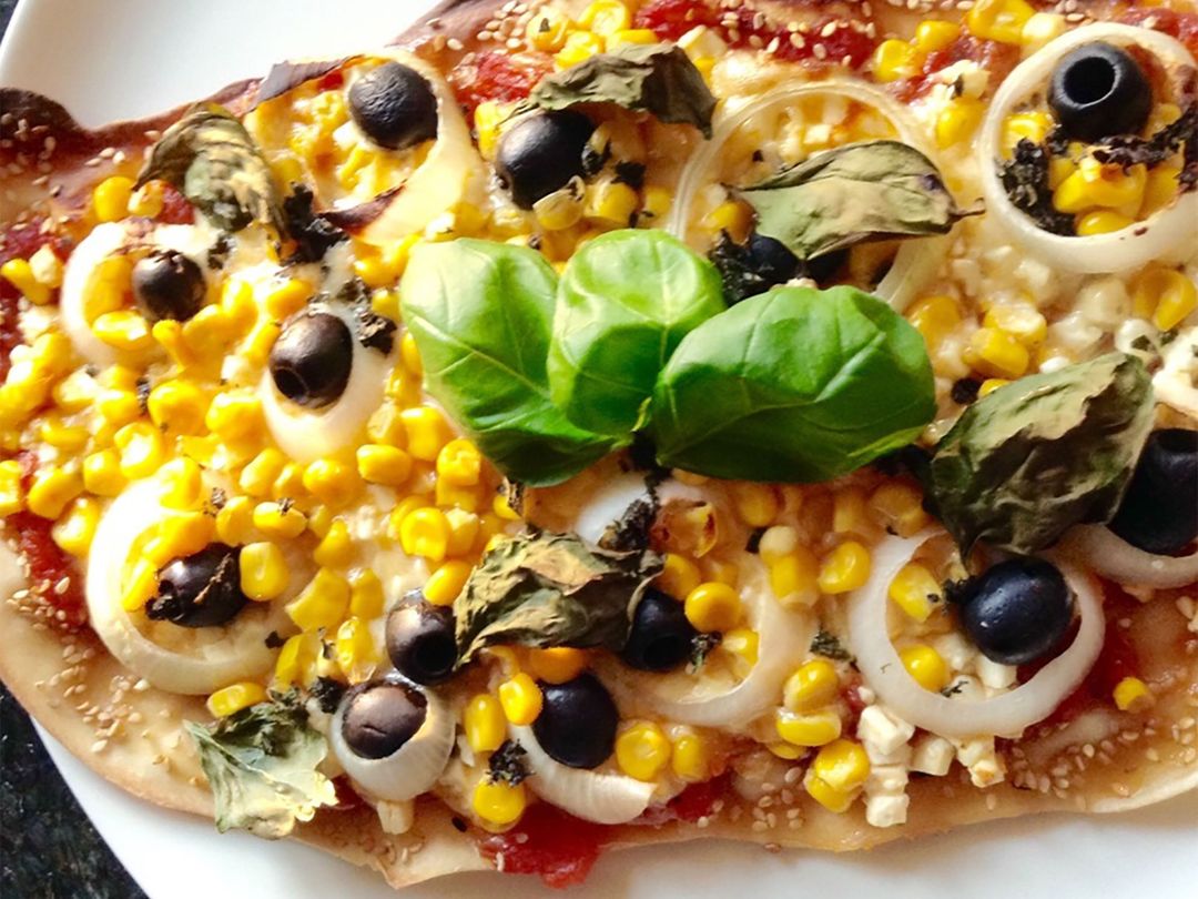 Pizza with sweetcorn, olives, and feta