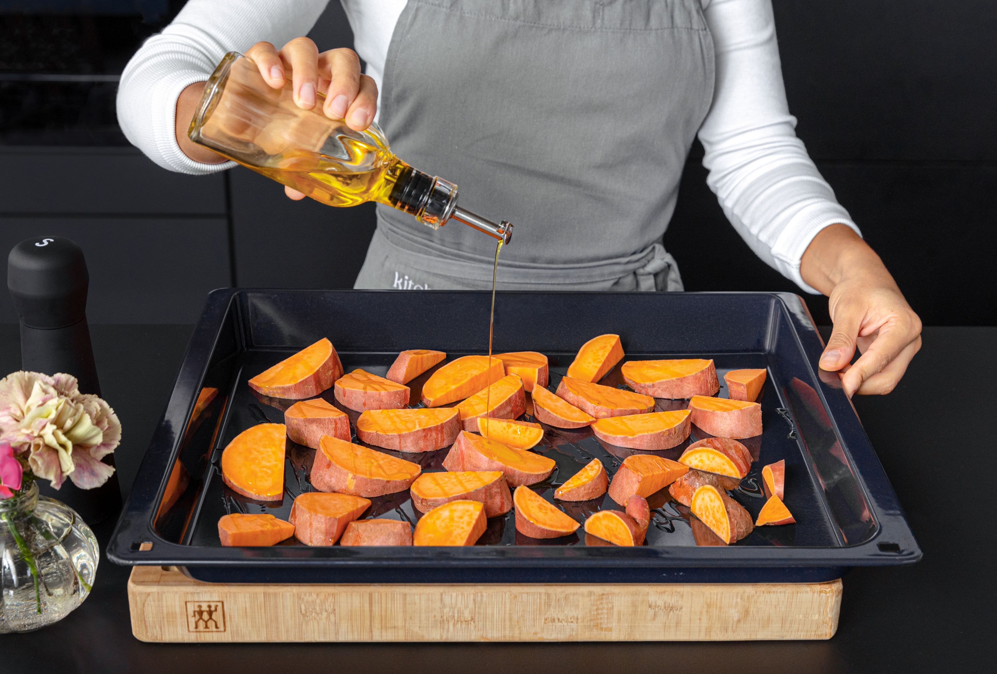 Preheat the oven to 200°C/400°F. With the skin on, slice the sweet potatoes into wedges. Transfer to a baking sheet, drizzle with some olive oil, season with salt and toss to combine. Let roast for approx. 25 - 30 min. or until the edges are brown and crisp.