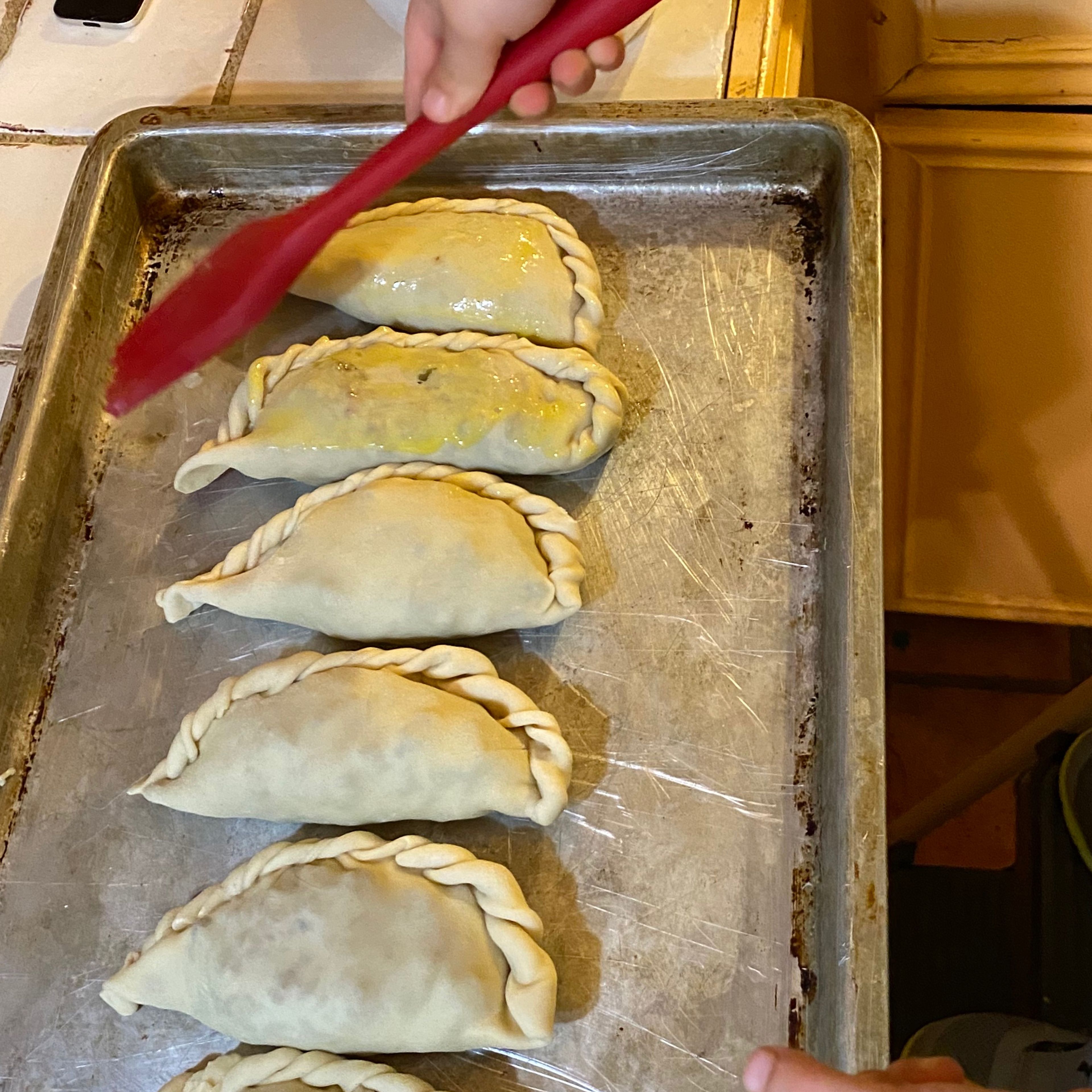 Place the empanadas 1 inch apart on a baking sheet sprayed with cooking spray. Place in the fridge for 30 minutes.