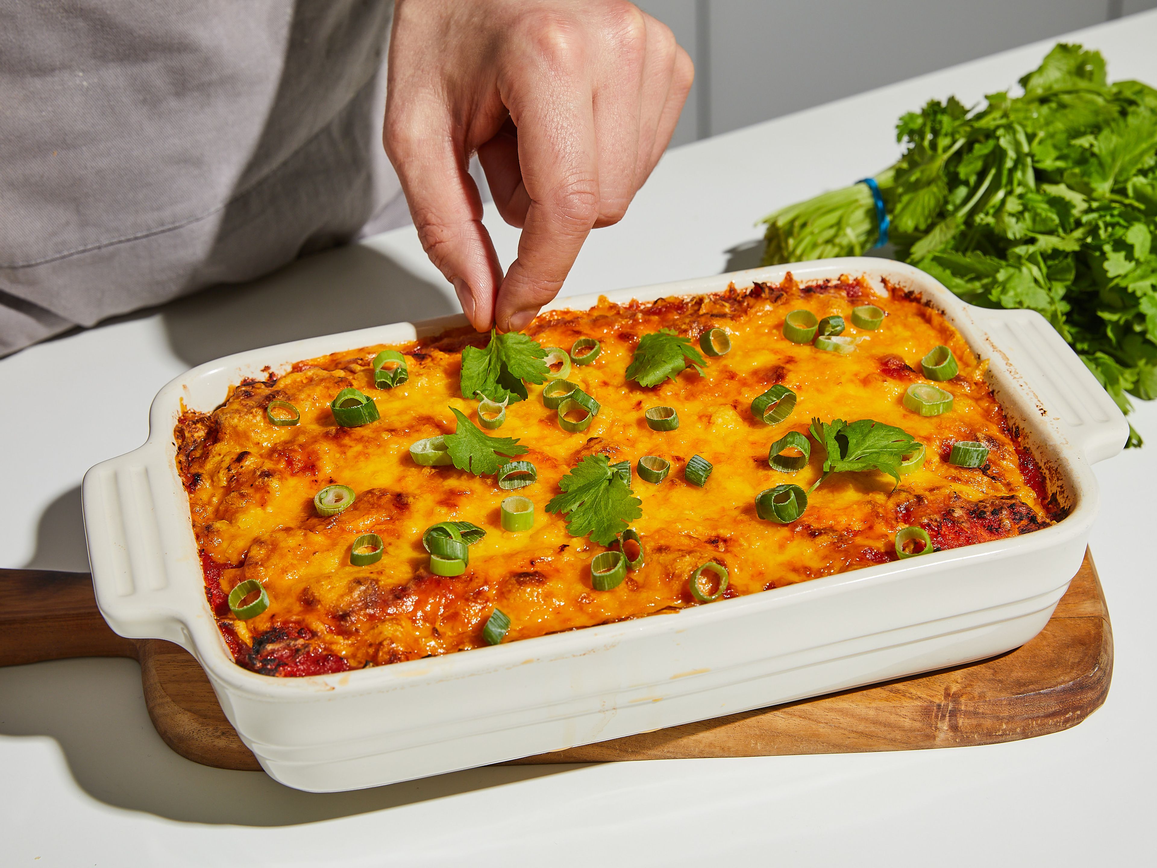 Bake the enchiladas for approx. 15–20 min., or until the cheese has melted and turns golden brown. Garnish with the green of the spring onion and chopped cilantro. Serve with sour cream.
