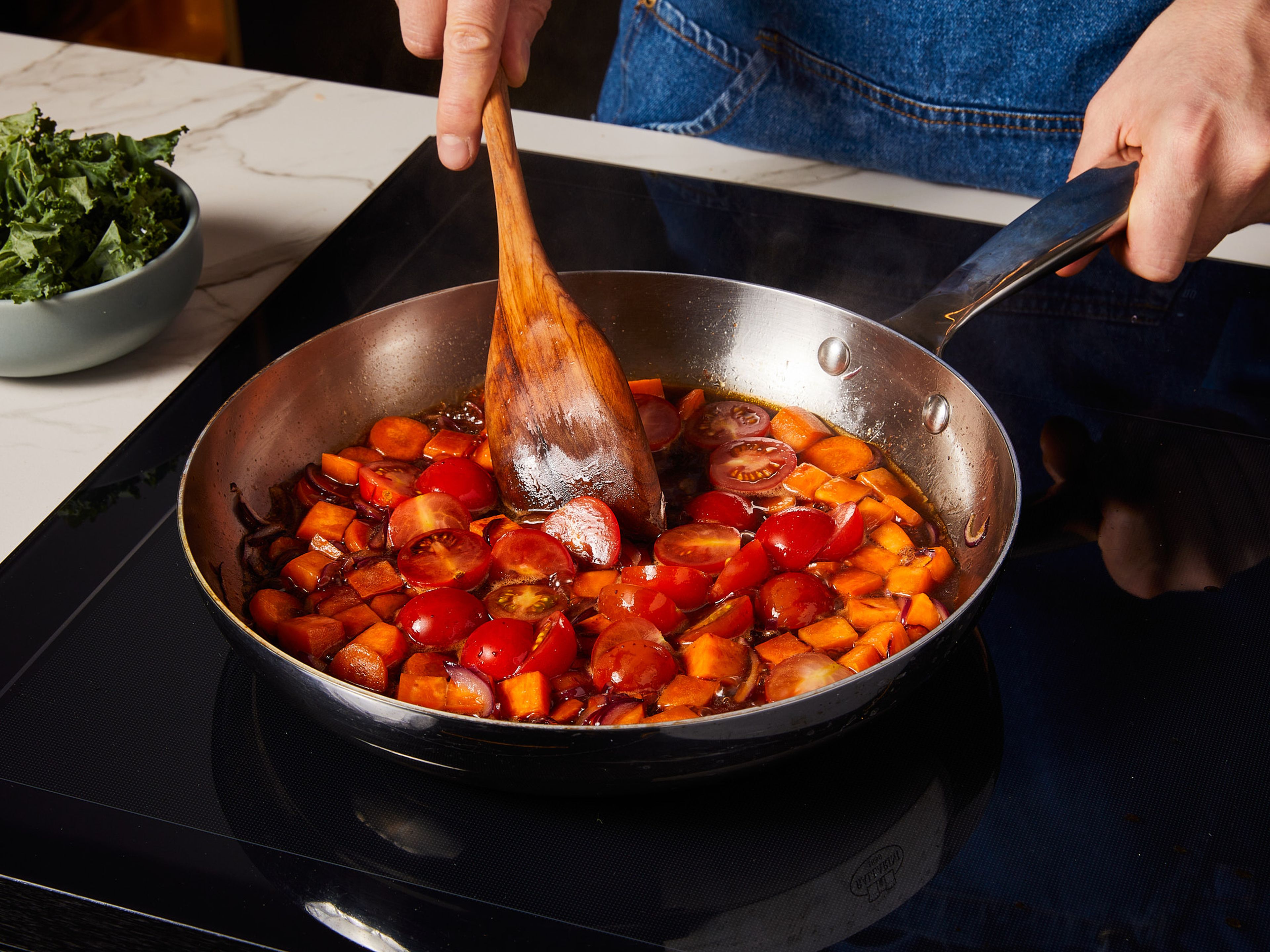 In einer großen Pfanne die Hälfte des Olivenöl bei mittlerer Hitze erhitzen. Karotten, Süßkartoffeln und Zwiebeln darin ca. 4–5 Min. anschwitzen, bis die Zwiebeln glasig sind. Cherrytomaten, Worcester Sauce, Balsamico und die Gemüsebrühe hinzufügen. Alles zugedeckt ca. 4–5 Min. köcheln lassen, bis das Gemüse weich ist.